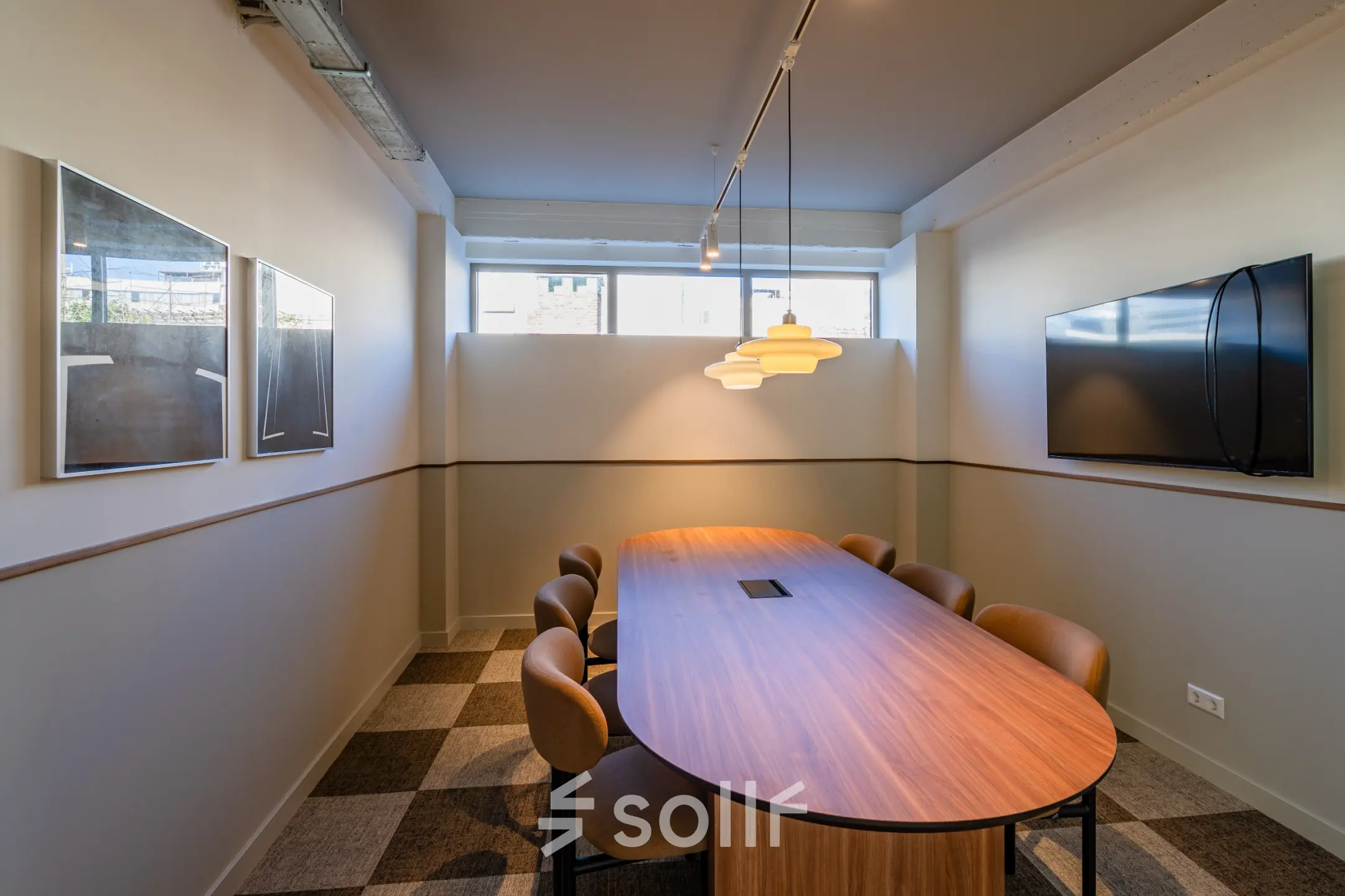 Vergaderruimte in een kantoorpand met een houten tafel, stoelen, kunst aan de muur en een flatscreen. Ideaal voor kantoorruimte huren in Rotterdam Centrum aan het Stadhuisplein 9-23.