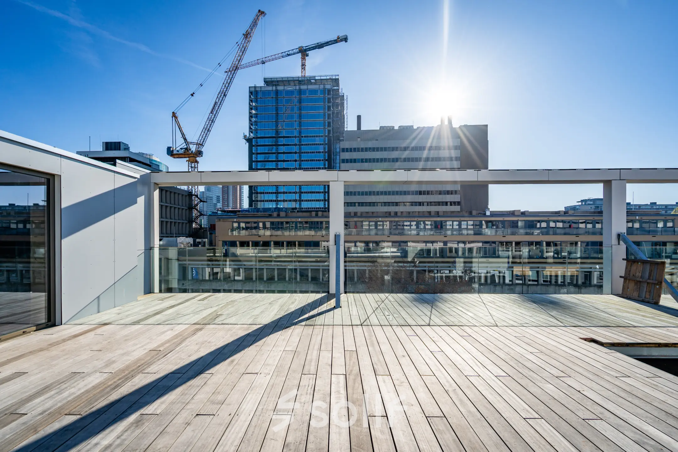 Dakterras in Rotterdam Centrum, Stadhuisplein 9-23, met uitzicht op een kantoorpand en de skyline. Ideale locatie voor een kantoorruimte huren met inspirerende omgeving.