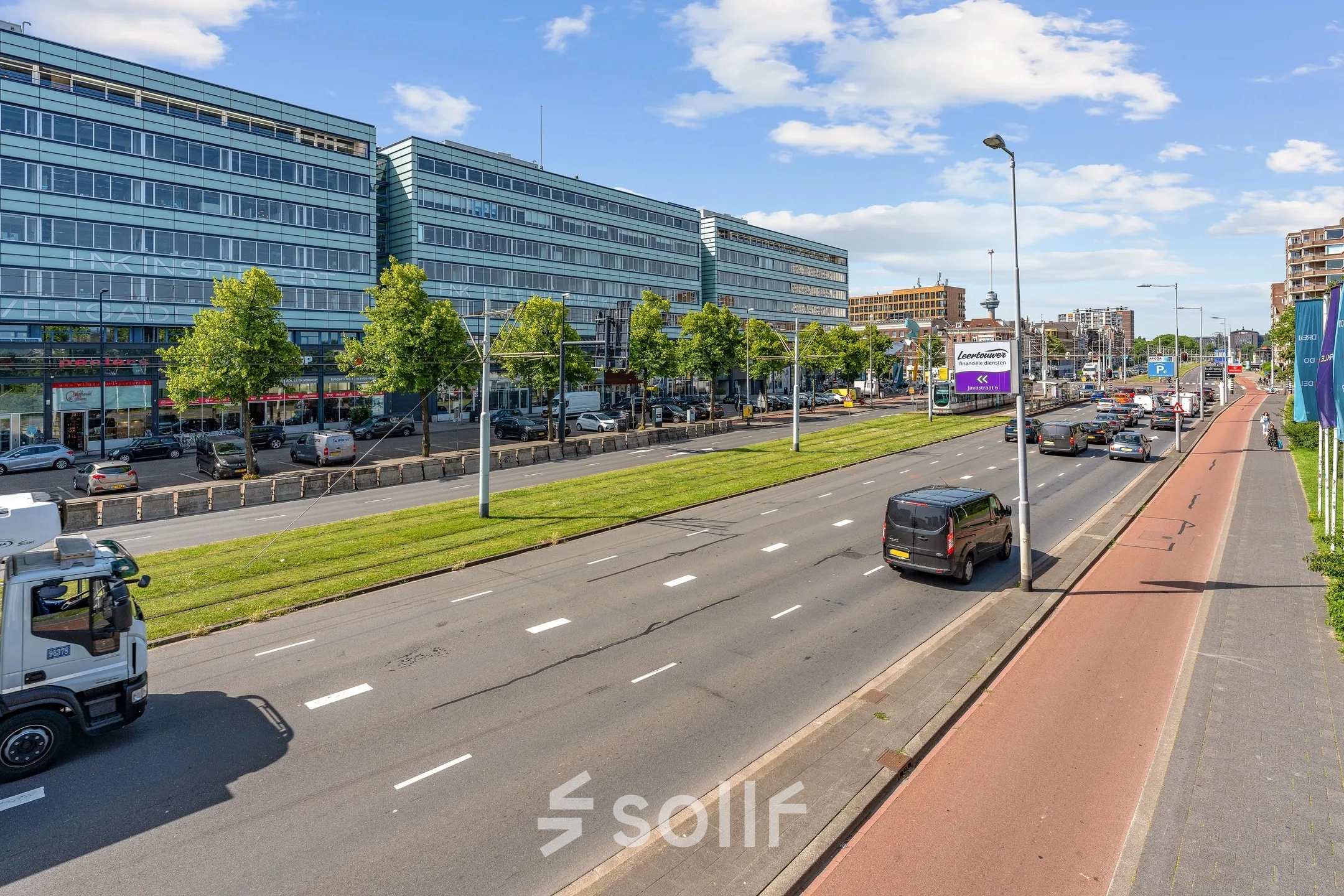 Uitzicht op een groot kantoorgebouw aan Vasteland 42-110 in Rotterdam Centrum, met een drukke weg en fietsenpad ervoor.