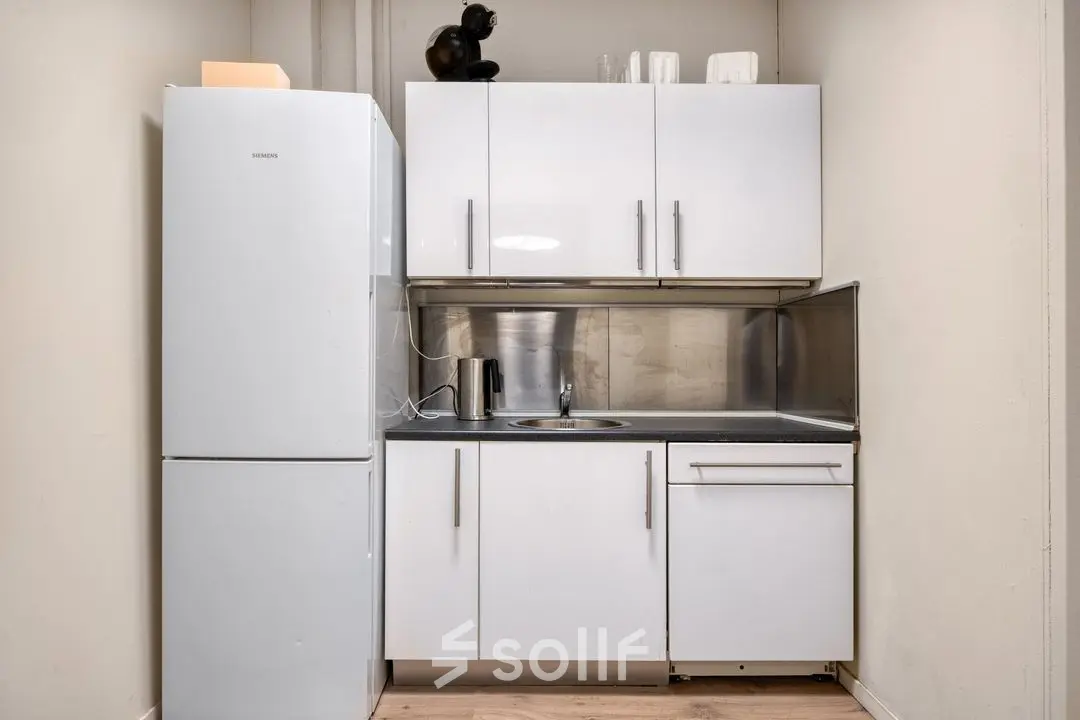 Compacte kitchenette in kantoorpand op Veerhaven 7, Rotterdam Centrum. Ideaal voor kleine pauzes tijdens het werk. Voorzien van koelkast en aanrechtblad. Geschikt bij kantoorruimte huren.