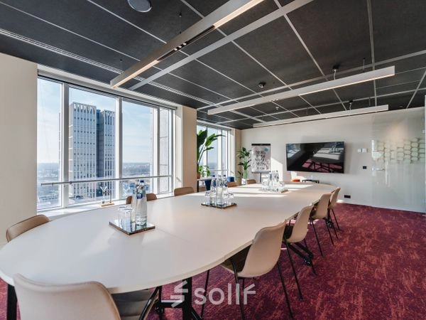 Moderne vergaderruimte met lange ovale tafel en comfortabele stoelen, grote ramen geven uitzicht op Rotterdam. Ideale kantoorruimte huren op Weena 690 voor effectieve meetings.