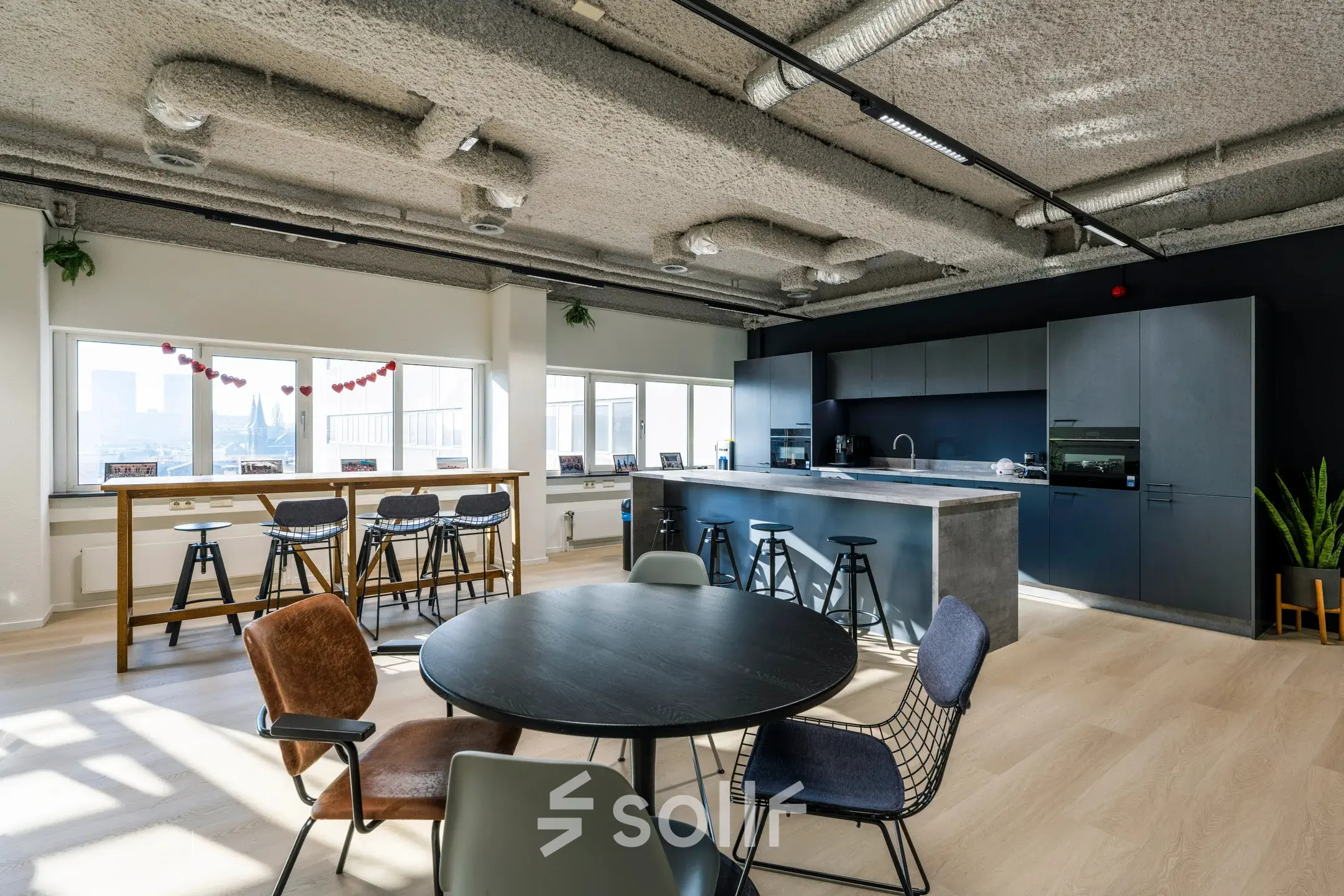 Moderne kantoorruimte te huur op Westblaak 180, Rotterdam Centrum, met open keuken en zitgedeelte, veel daglicht en stijlvolle meubels.