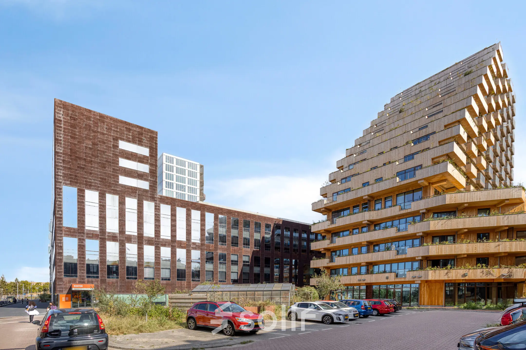 Moderne kantoorpand aan de Kratonkade 7-27 in Rotterdam Delfshaven, omgeven door andere eigentijdse gebouwen en met een ruime parkeerplaats ervoor.