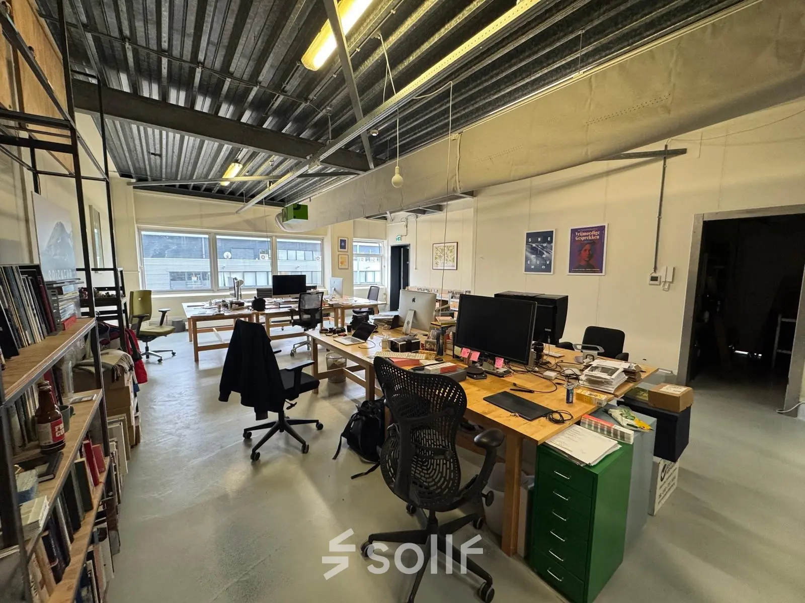 Kantoorruimte huren op Van Helmontstraat 17-23 in Rotterdam Delfshaven, ingericht als open werkruimte met bureaus, stoelen en persoonlijke spullen. Ruimte is licht en functioneel voor kantoren.