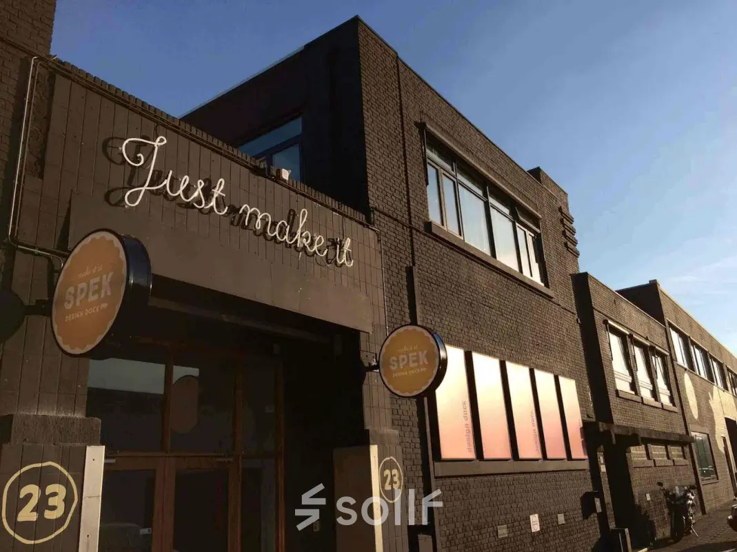 Industrieel kantoorpand aan Van Helmontstraat 17-23 in Rotterdam Delfshaven met moderne gevel en opvallend uithangbord, ideaal voor unieke kantoorruimte huren.