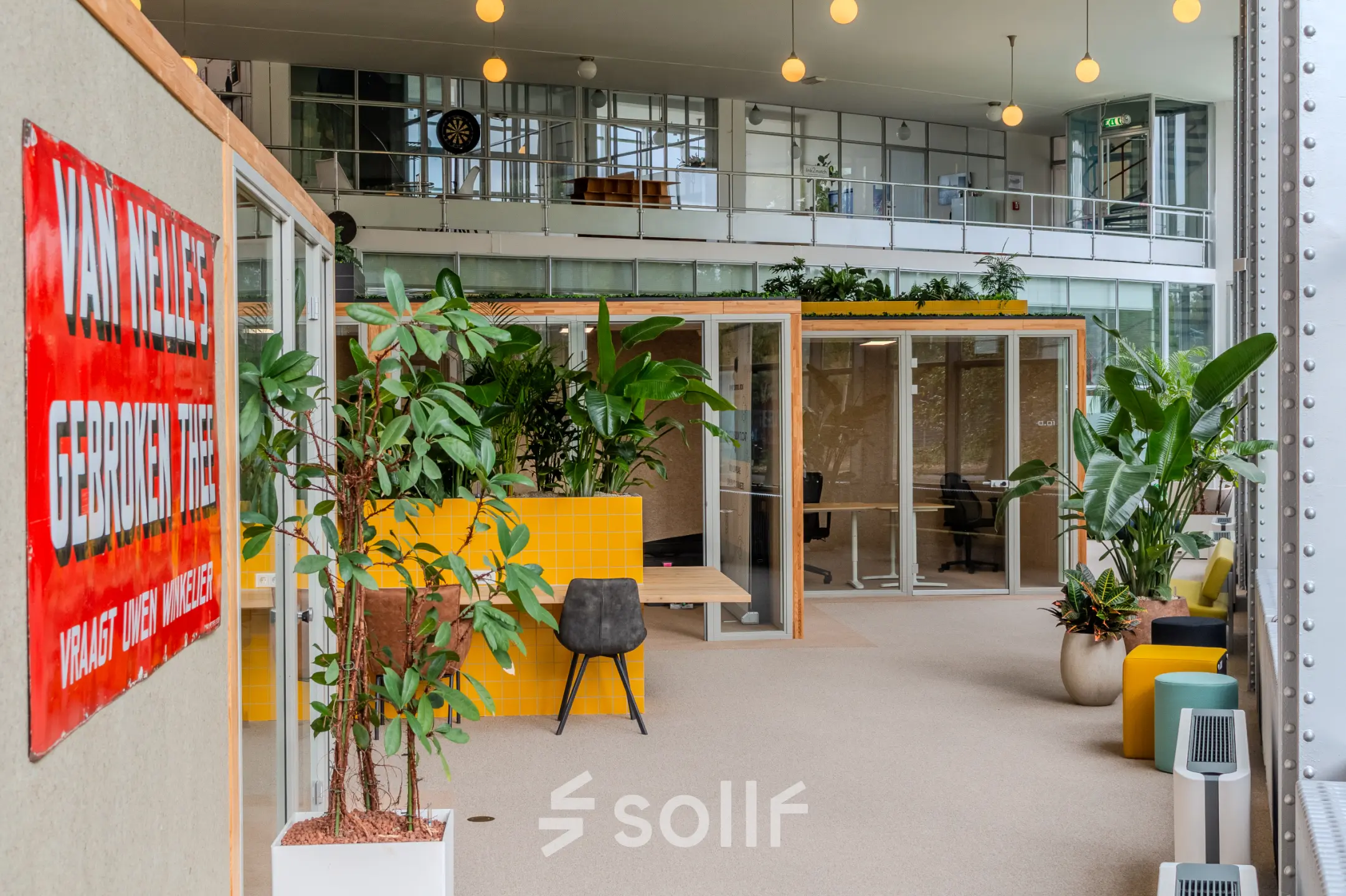 Heldere en moderne kantoorruimte op Van Nelleweg 1, Rotterdam Delfshaven, met glazen kantoorpanden en groen decor, ideaal om te huren.