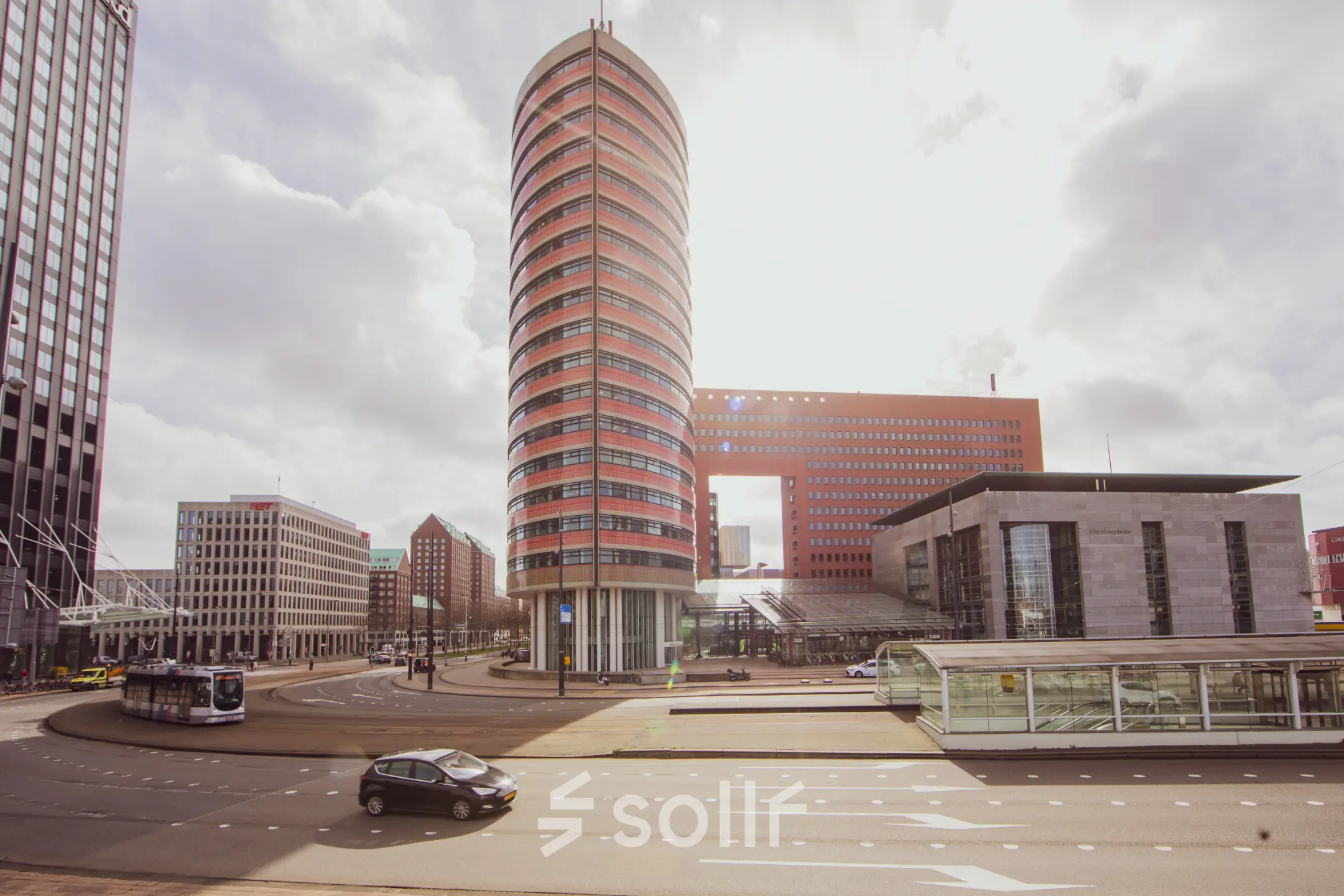 Buitenzijde van het opvallende kantoorpand op Wilhelminaplein 1-40 in Rotterdam Kop van Zuid, met zicht op de karakteristieke ronde toren en omliggende architectuur.