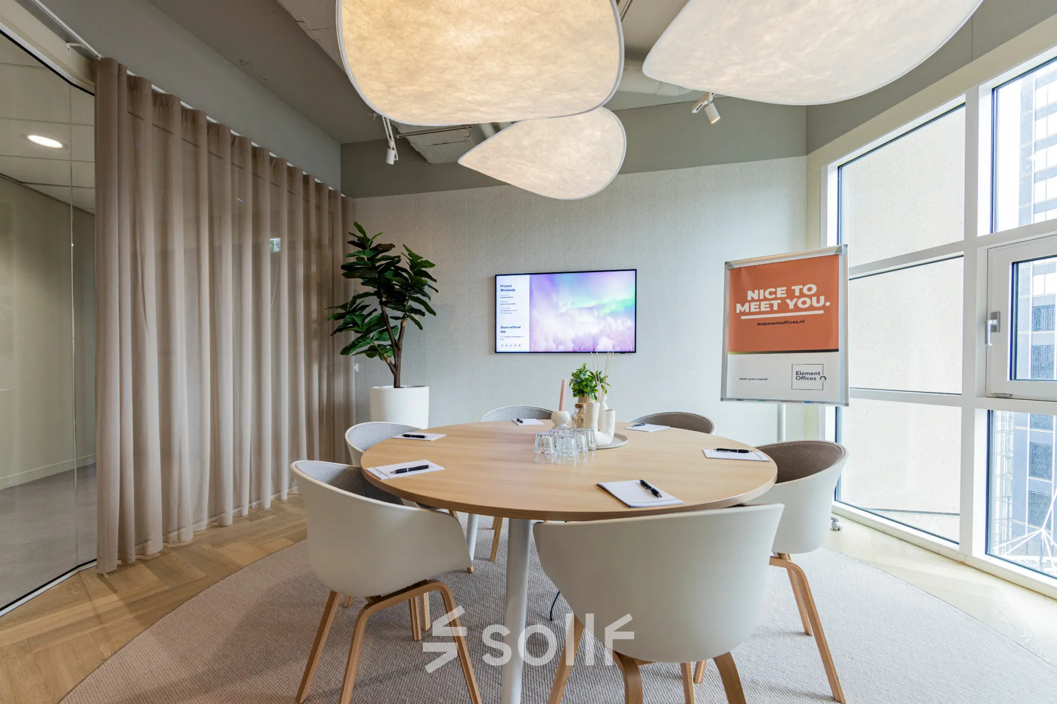Lichte kantoorruimte huren op Wilhelminaplein 1-40, Rotterdam Kop van Zuid, met een moderne vergadertafel, comfortabele stoelen en groot scherm voor presentaties.