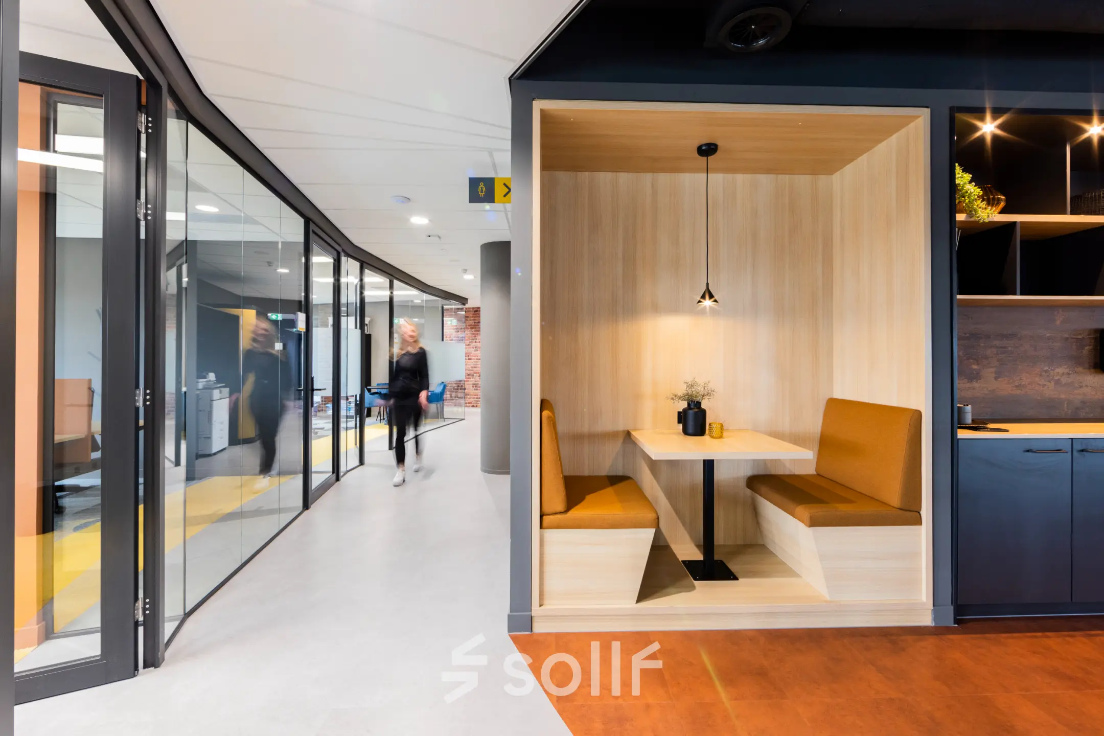 Moderne kantoorruimte met glazen wanden, een gezellige zithoek, en houten details op Wilhelminaplein 1-40, Rotterdam Kop van Zuid, ideaal voor wie een kantoorpand wil huren.