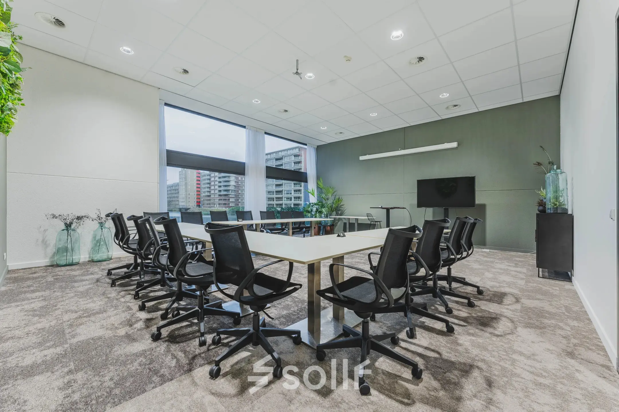 Moderne vergaderruimte in een kantoorpand aan Oostmaaslaan 71, Rotterdam Kralingen, voorzien van een grote tafel omringd door stoelen, met uitzicht op de stad.