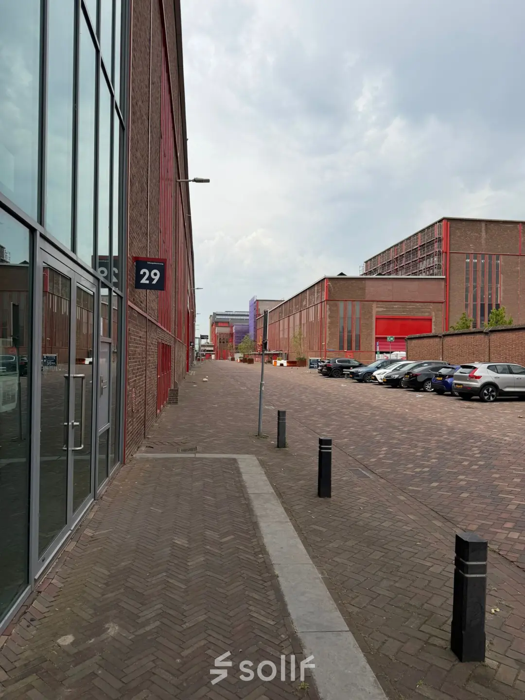 Bakstenen exterieur van kantoorpand op Scheepsbouwweg 29, Rotterdam Waalhaven, met parkeerplaatsen en een rustige straat. Ideale locatie voor kantoorruimte huren.