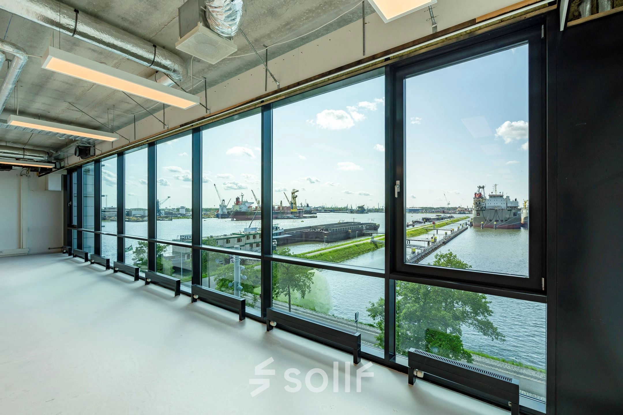 Kantoorruimte met grote ramen en uitzicht op de haven, gelegen op Waalhaven O.z. 85 in Rotterdam. Ideale plek om een kantoor te huren met een prachtig uitzicht.