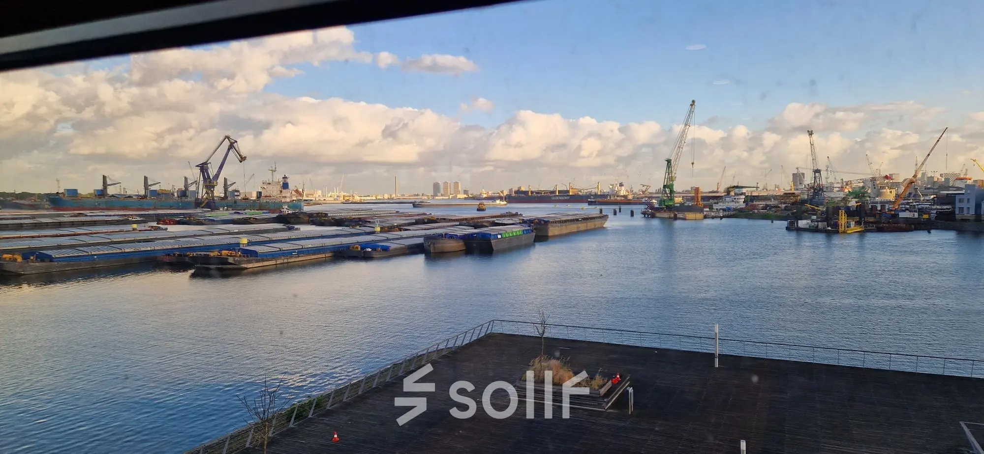 Uitzicht vanuit een kantoor op Waalhaven Zuidzijde 21, Rotterdam, met een panoramisch zicht op de haven met kranen en schepen.
