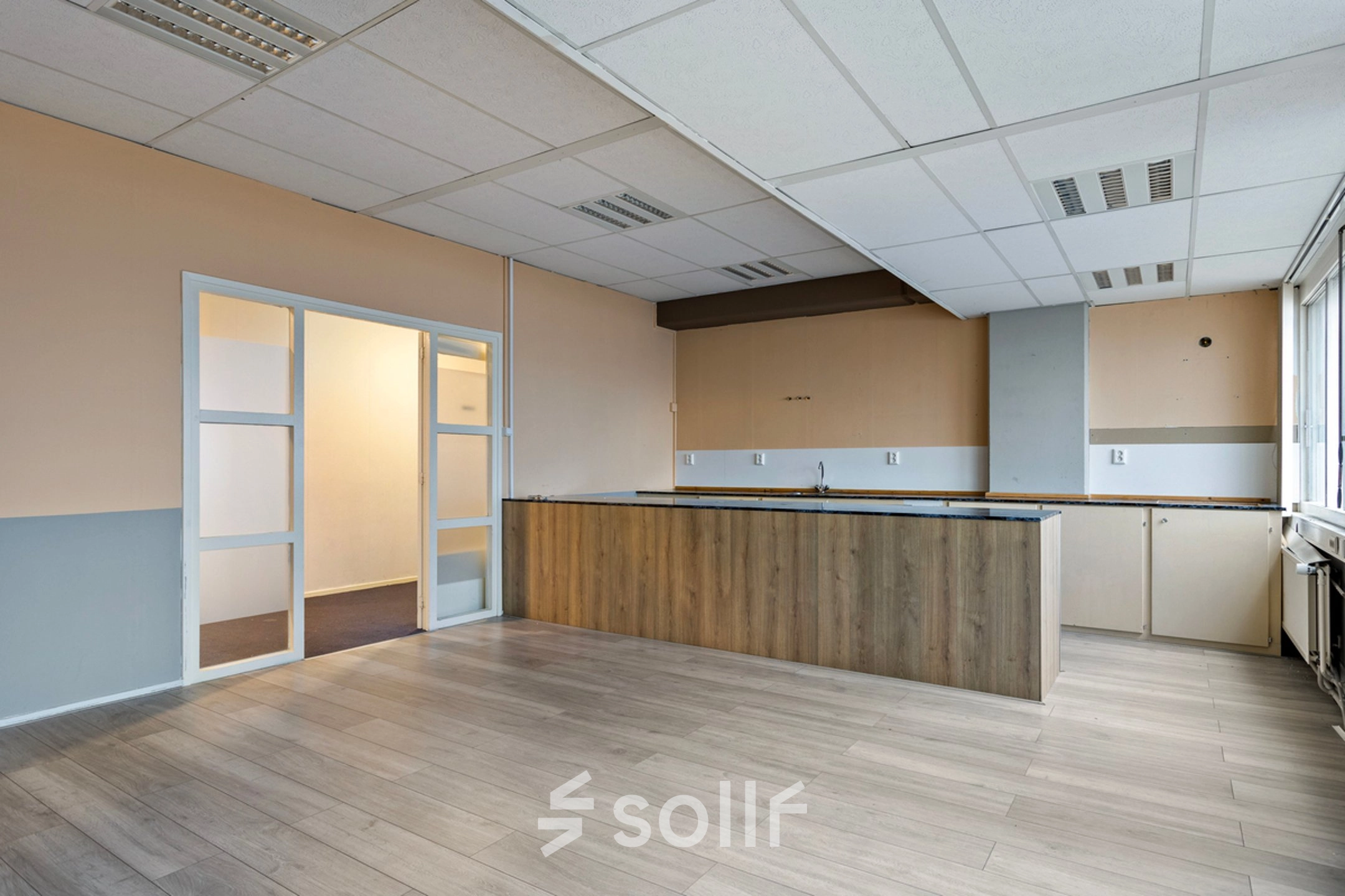 Interieur van een leeg kantoor op de Brauwweg 52-66, Schiedam, met lichte muren, houten vloer en ingebouwde kast; kantoorruimte huren mogelijk.