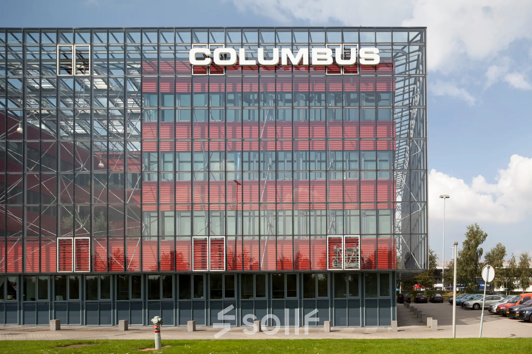 Exterieur van het kantoorpand Columbus op Folkstoneweg 2-56 in Schiphol Airport met opvallende rode en glazen gevel.