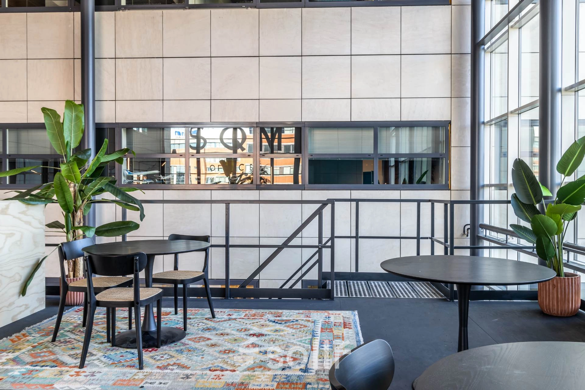 Een moderne kantoorruimte op Beechavenue 54-100 in Schiphol Rijk, met ruime ramen, diverse planten en zitgelegenheid. Geschikt voor kantoorruimte huren.