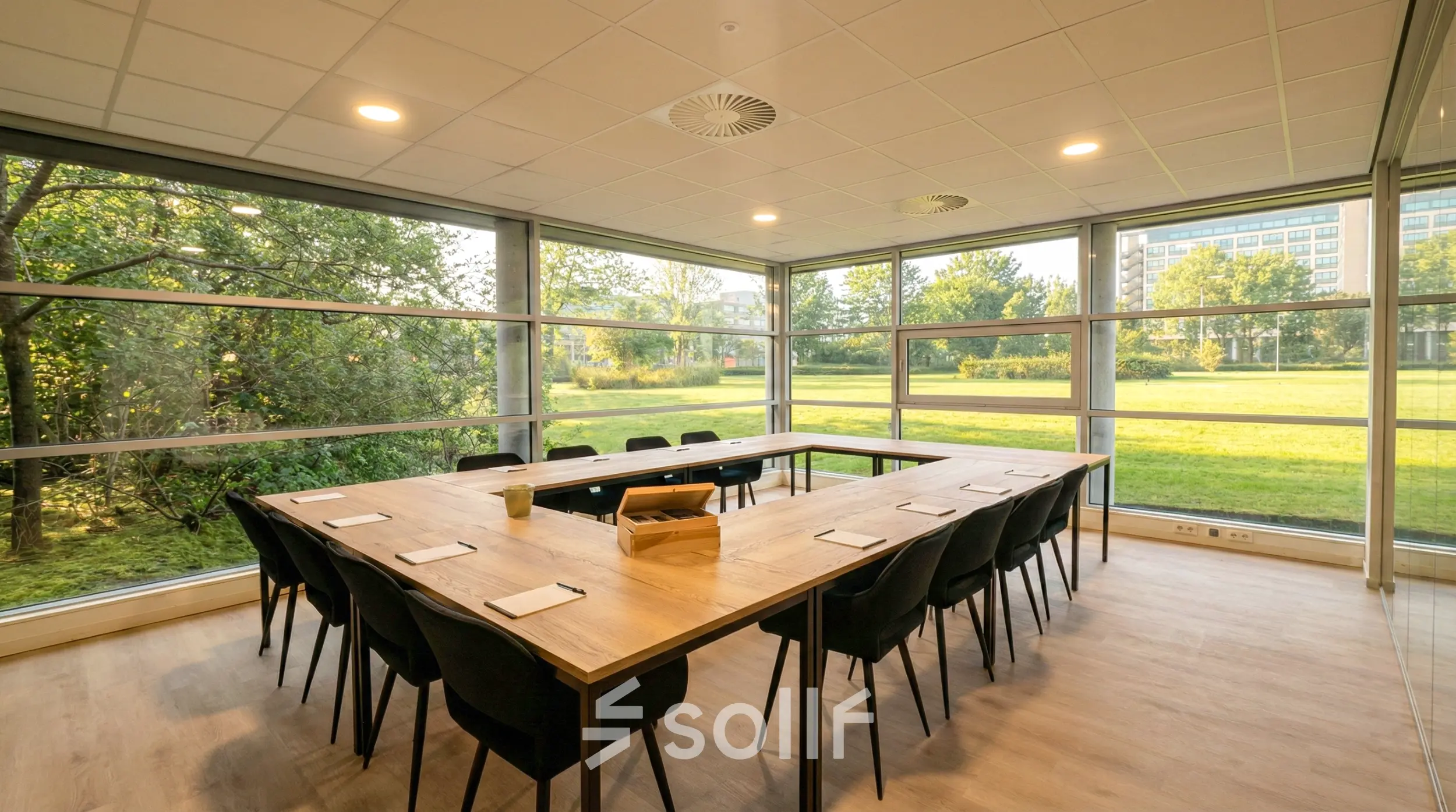 Vergaderruimte met lange houten tafel en stoelen in kantoorpand te huur op Boeing Avenue 1-19, Schiphol Rijk, met uitzicht op groene buitenruimte.