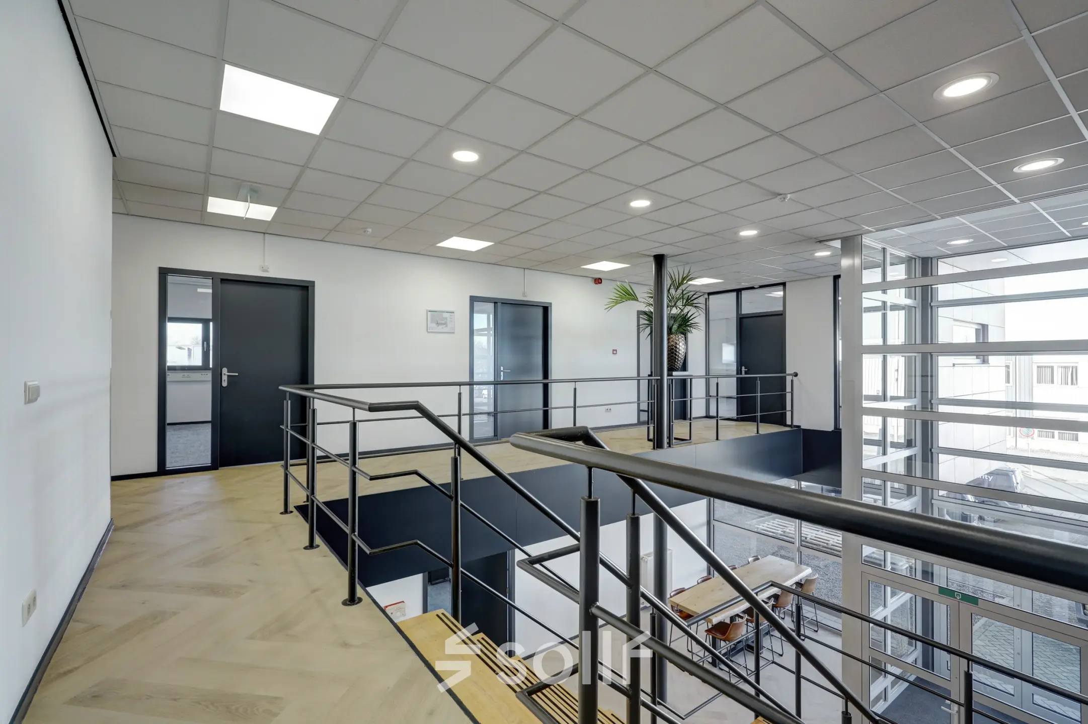 Moderne kantoorruimte met zicht op trap en glazen wanden, ideaal voor wie kantoorruimte wil huren in Sittard.