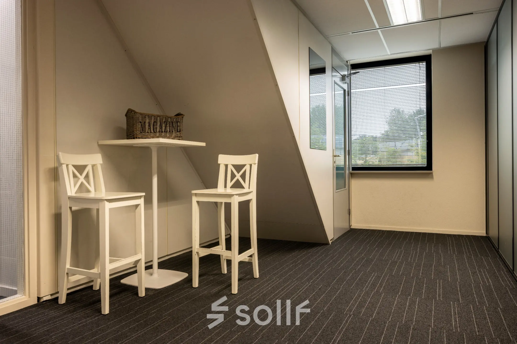 Kantoorruimte huren aan Curieweg 9 in Spijkenisse met twee hoge witte krukken en een tafel, minimalistisch ingericht en geschikt voor zakelijke gesprekken of ontspanning.