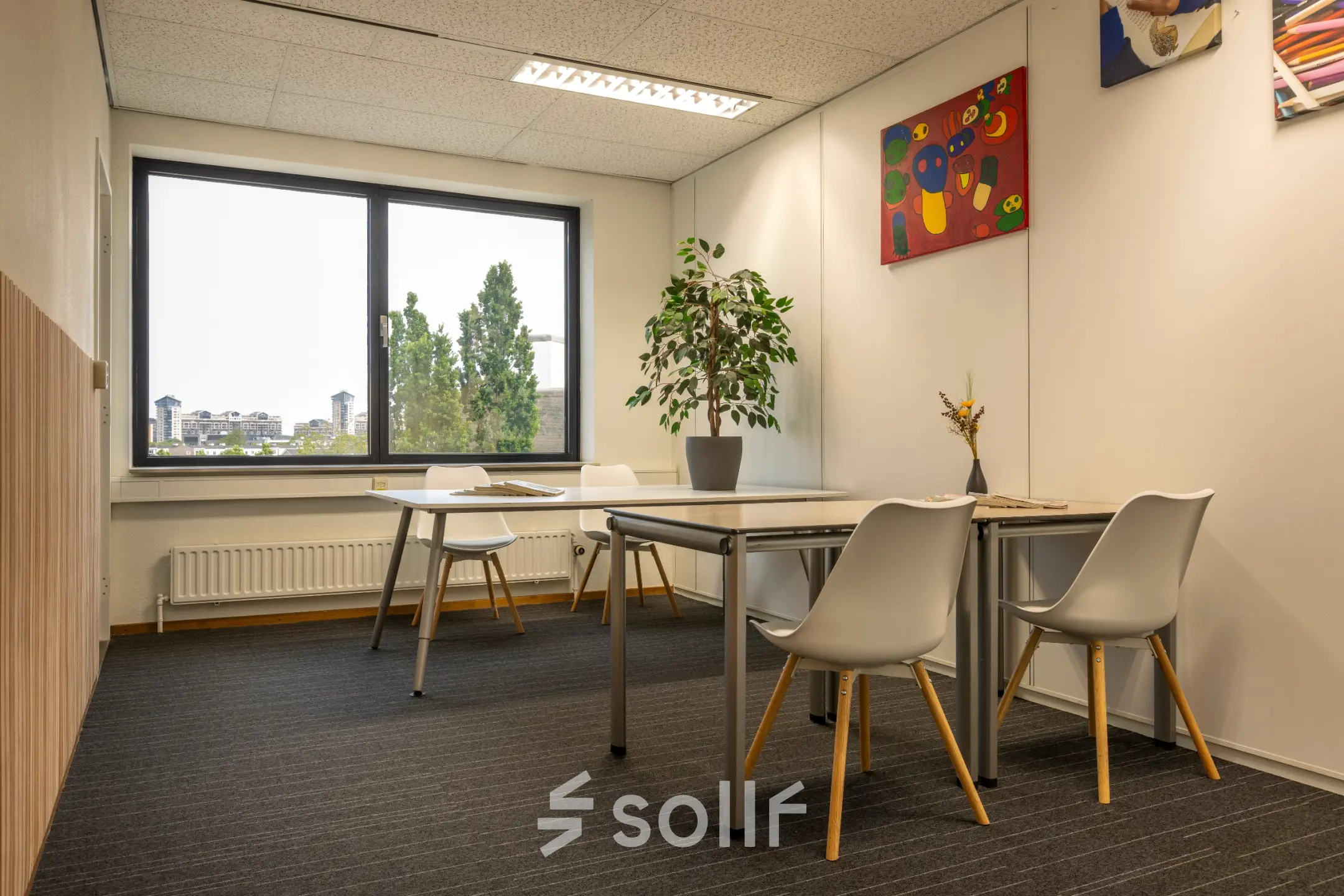 Kantoorruimte huren op Curieweg 9, Spijkenisse met strak ingerichte werkplekken, decoratieve kunstwerken en grote ramen voor natuurlijk licht.
