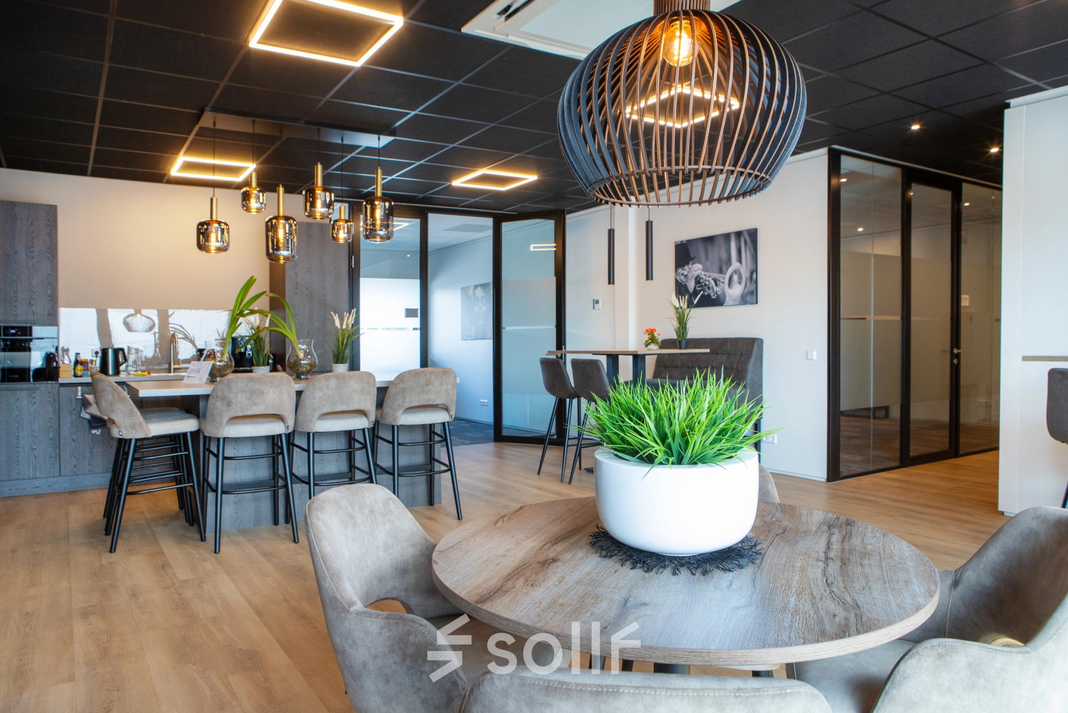Stijlvol ingerichte kantoorruimte met houten vloeren, moderne verlichting en verschillende zitgelegenheden op Kapitein Rondairestraat 8 in Tilburg. Mogelijkheid om dit kantoorpand te huren voor een inspirerende werkomgeving.