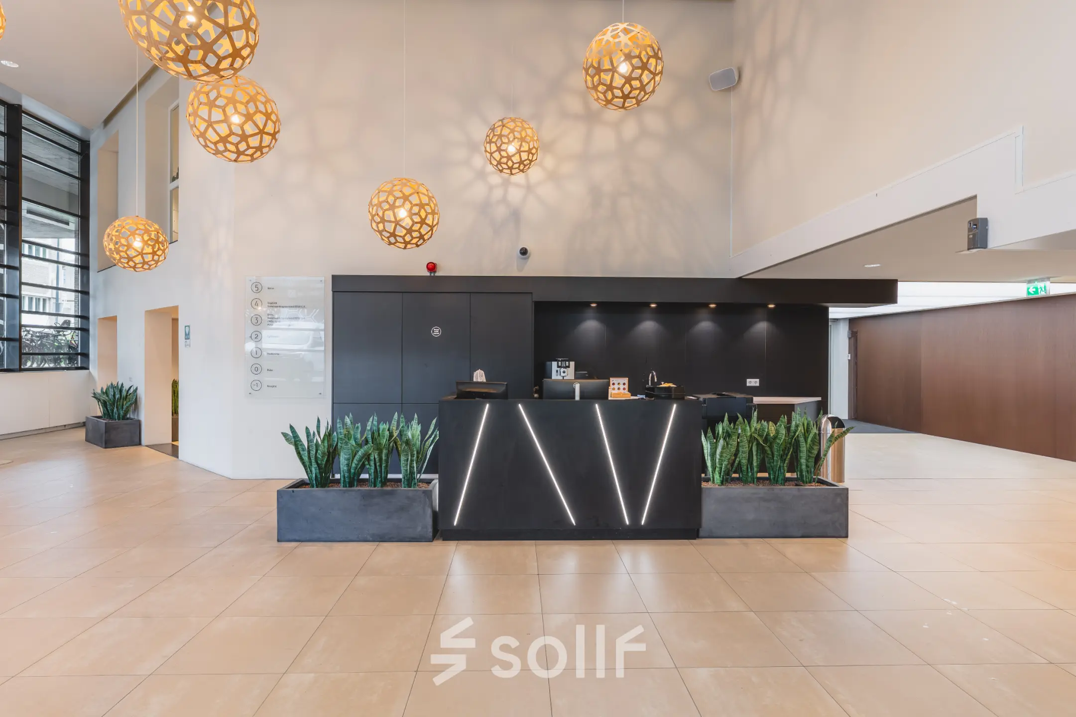 Moderne entree van een kantoorpand bij Utrecht Centraal Station, met stijlvolle verlichting en plantenbakken. Ideaal voor kantoorruimte huren op Leidseveer 2-10.