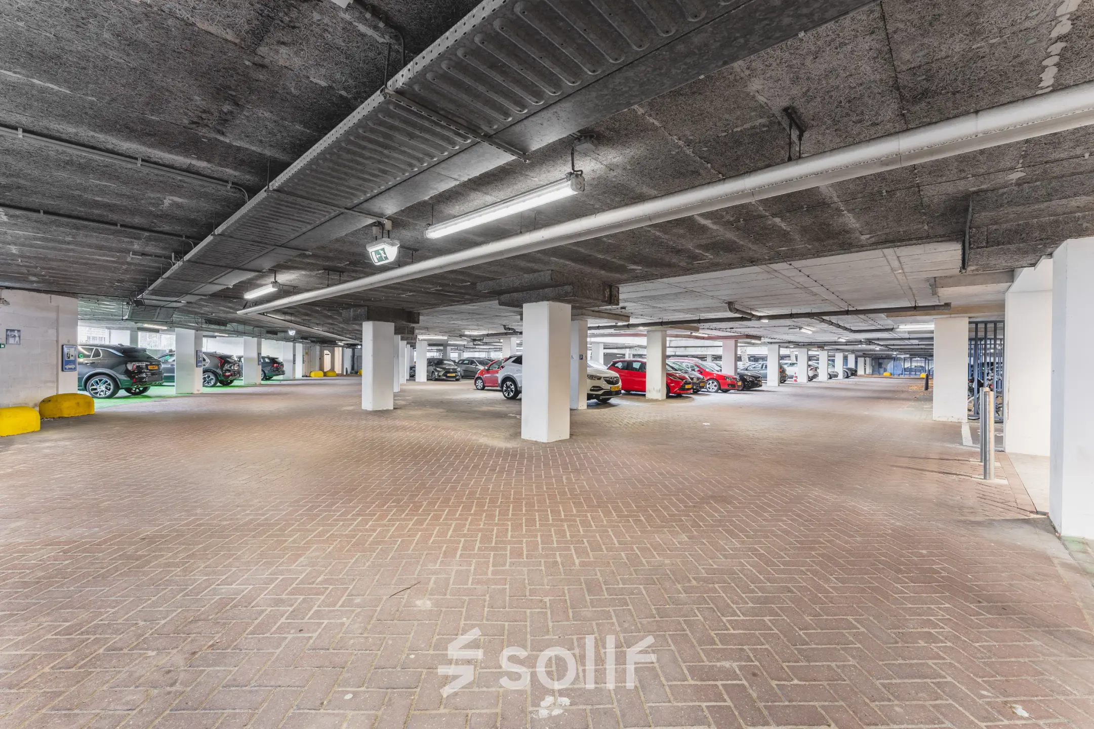 Parkeergarage op Leidseveer 2-10 nabij Utrecht Centraal Station met diverse geparkeerde auto's en voldoende ruimte om te parkeren.