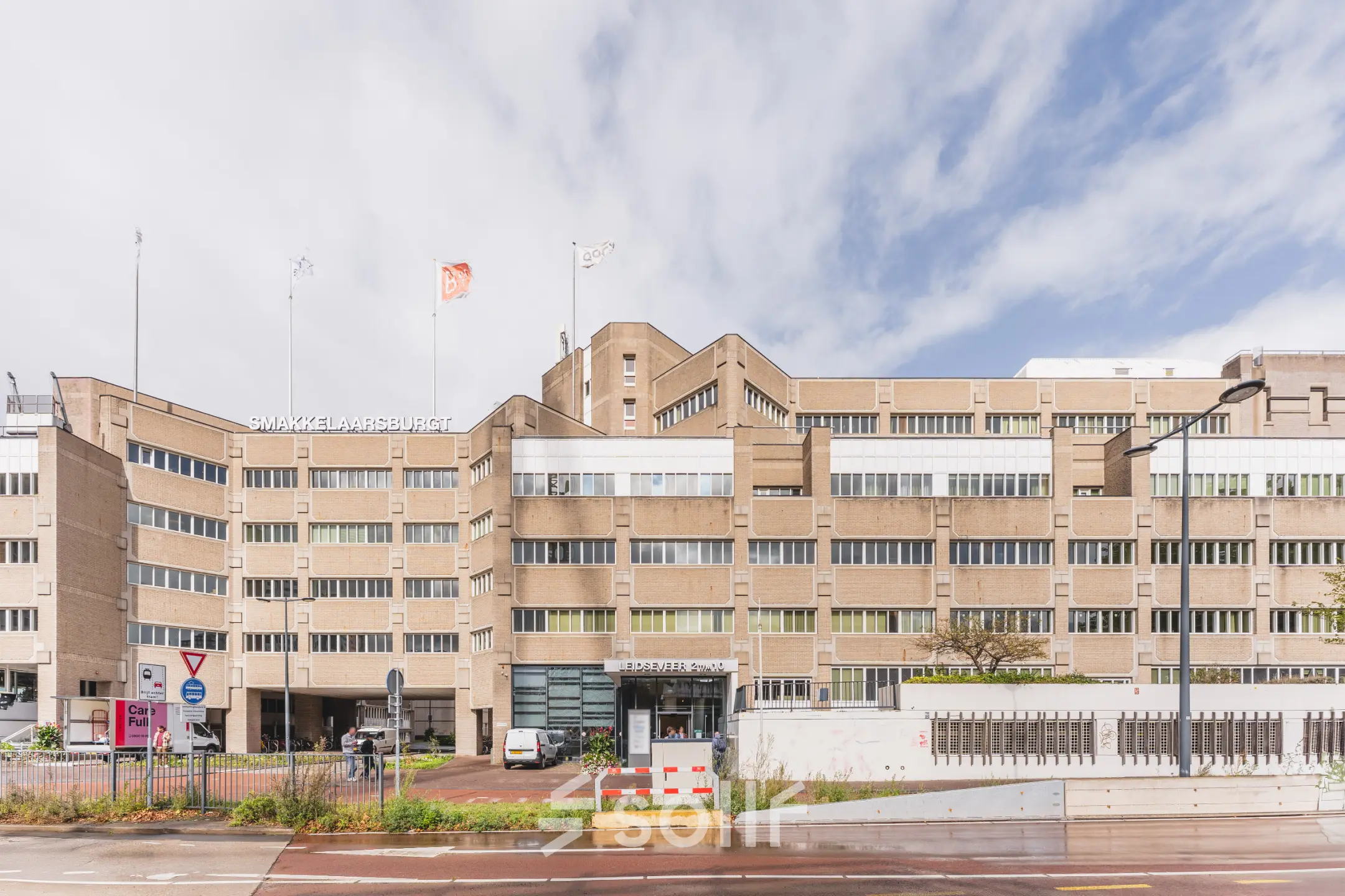 Kantoorpand aan Leidseveer 2-10 bij Utrecht Centraal Station met meerdere ingangen en parkeerplaatsen aan de voorkant van het gebouw.