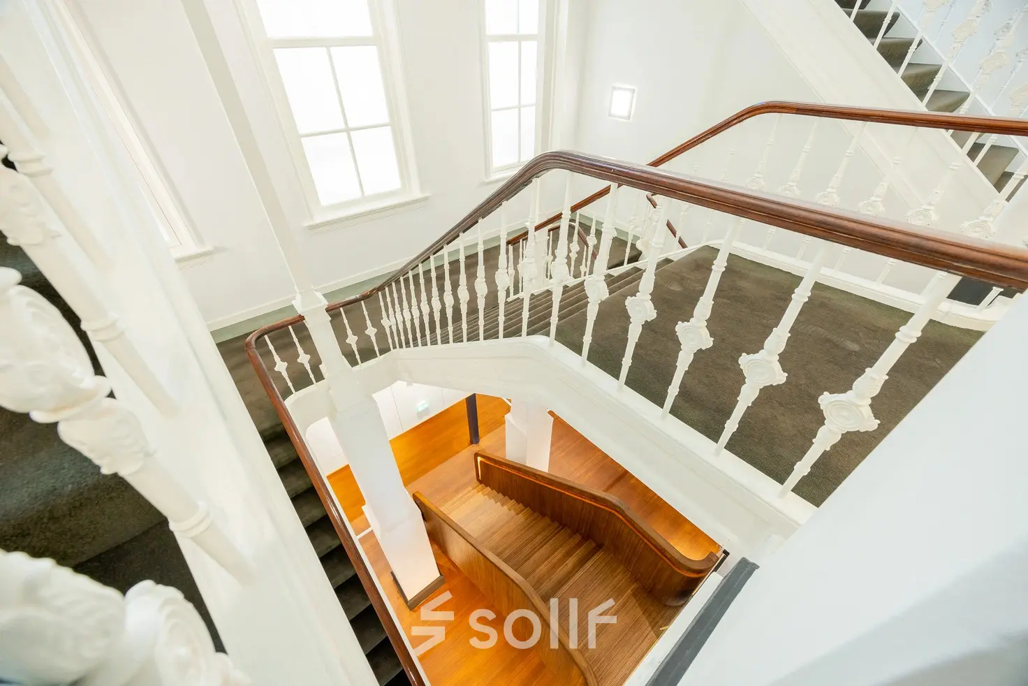 Trap in een historisch kantoorpand aan Moreelsepark 1, Utrecht Centraal Station, met witte balustrades en houten treden, zonder aanwezige personen.
