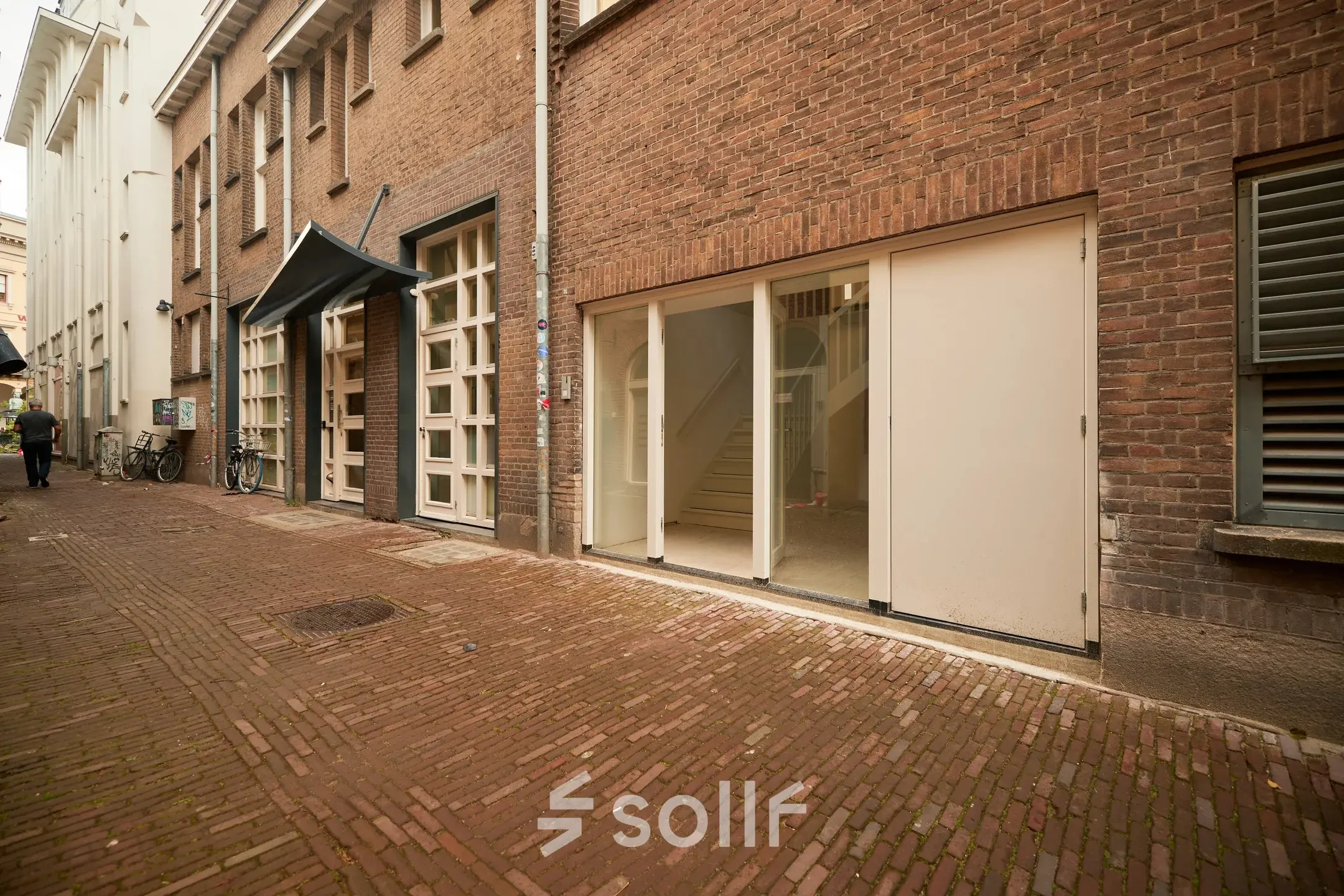 Exterieur van kantoorpand aan de Oudegracht 161 in Utrecht Centrum met bakstenen gevel en grote ramen.