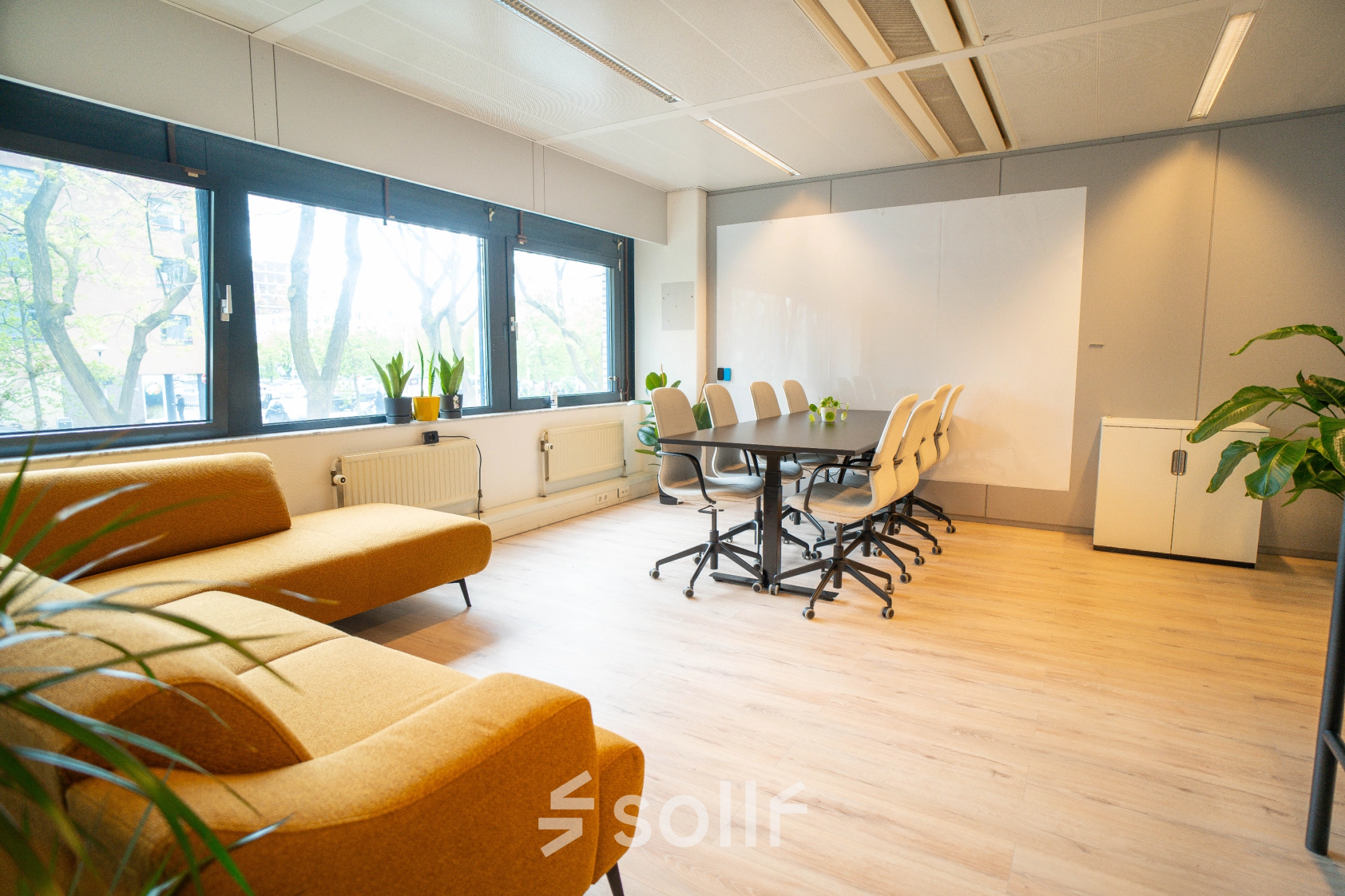 Kantoorruimte huren in Utrecht Kanaleneiland op Bernadottelaan 13 met lichte vergaderruimte voorzien van een houten vloer, comfortabele stoelen rond een grote tafel en grote ramen.
