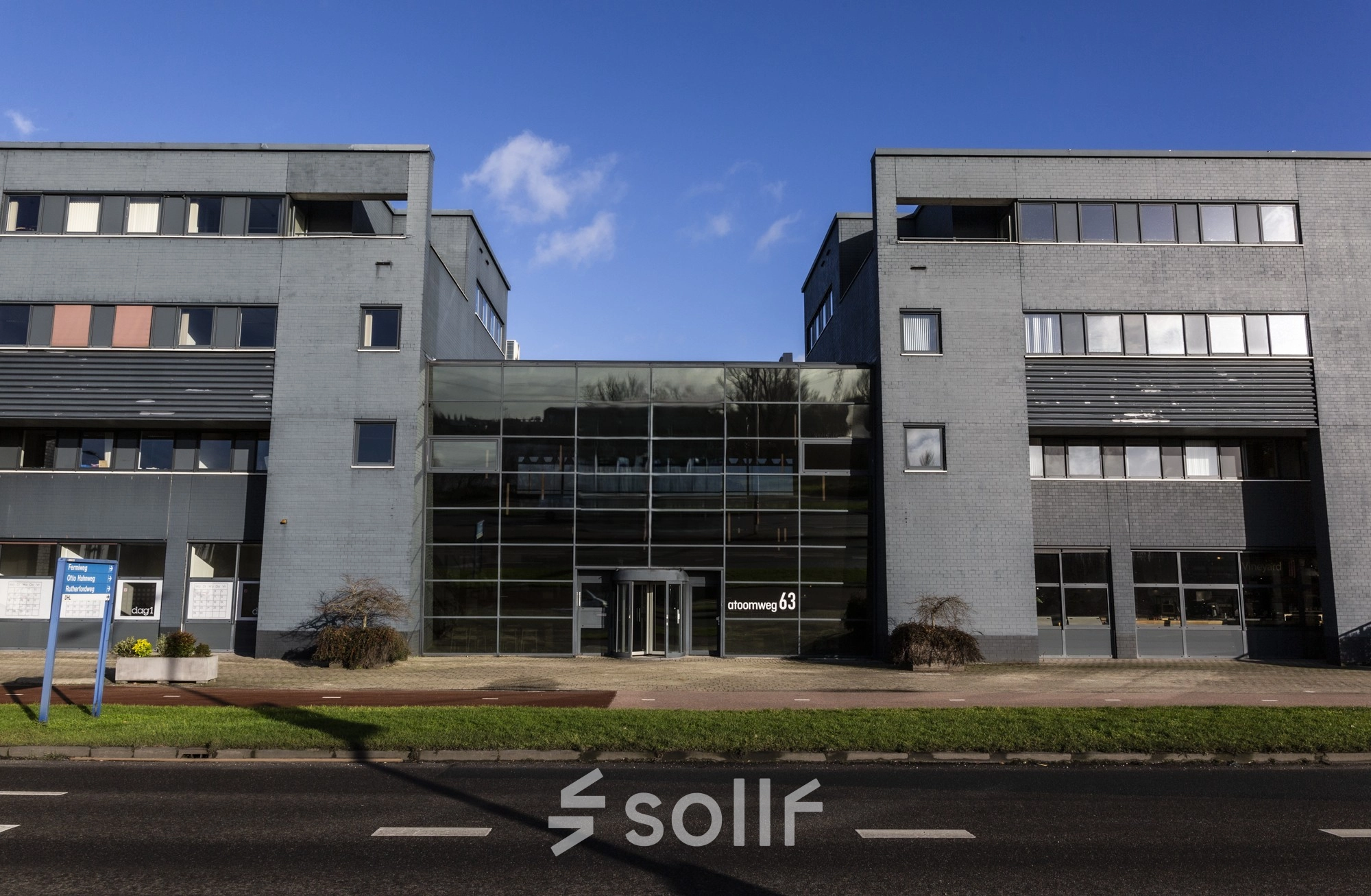 Het kantoorpand aan de Atoomweg 63 in Utrecht Lage Weide toont een modern gebouw met glazen entree en grijze gevel, ideaal voor kantoorruimte huren.