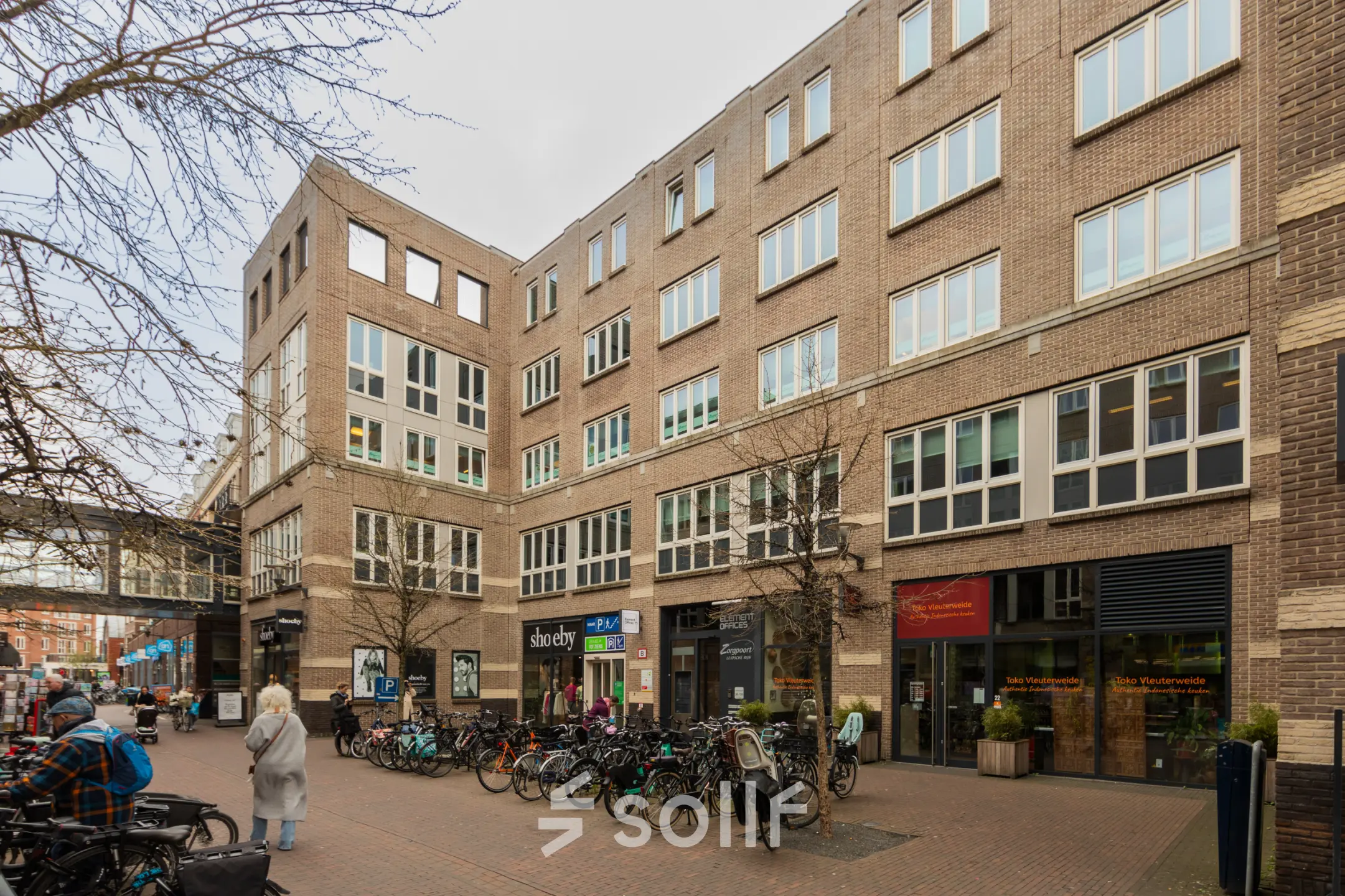 Bakstenen kantoorpand op Middenburcht 136 in Utrecht Leidsche Rijn met fietsenstalling en verschillende winkels op de begane grond. Ideale locatie voor kantoorruimte huren.