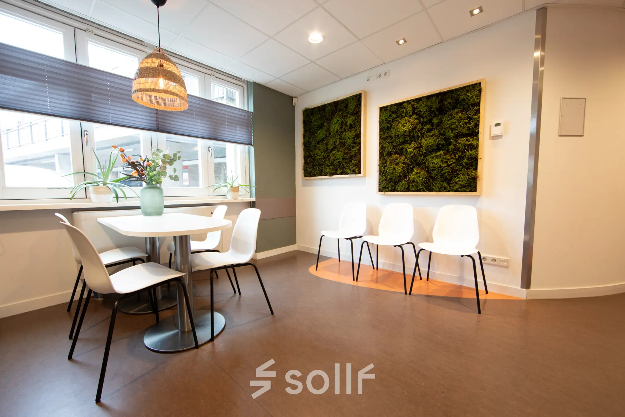 Lichte kantoorruimte in Utrecht Leidsche Rijn met ronde tafel en stoelen, kunst aan de muur en veel daglicht. Ideaal om te huren als vergaderruimte.