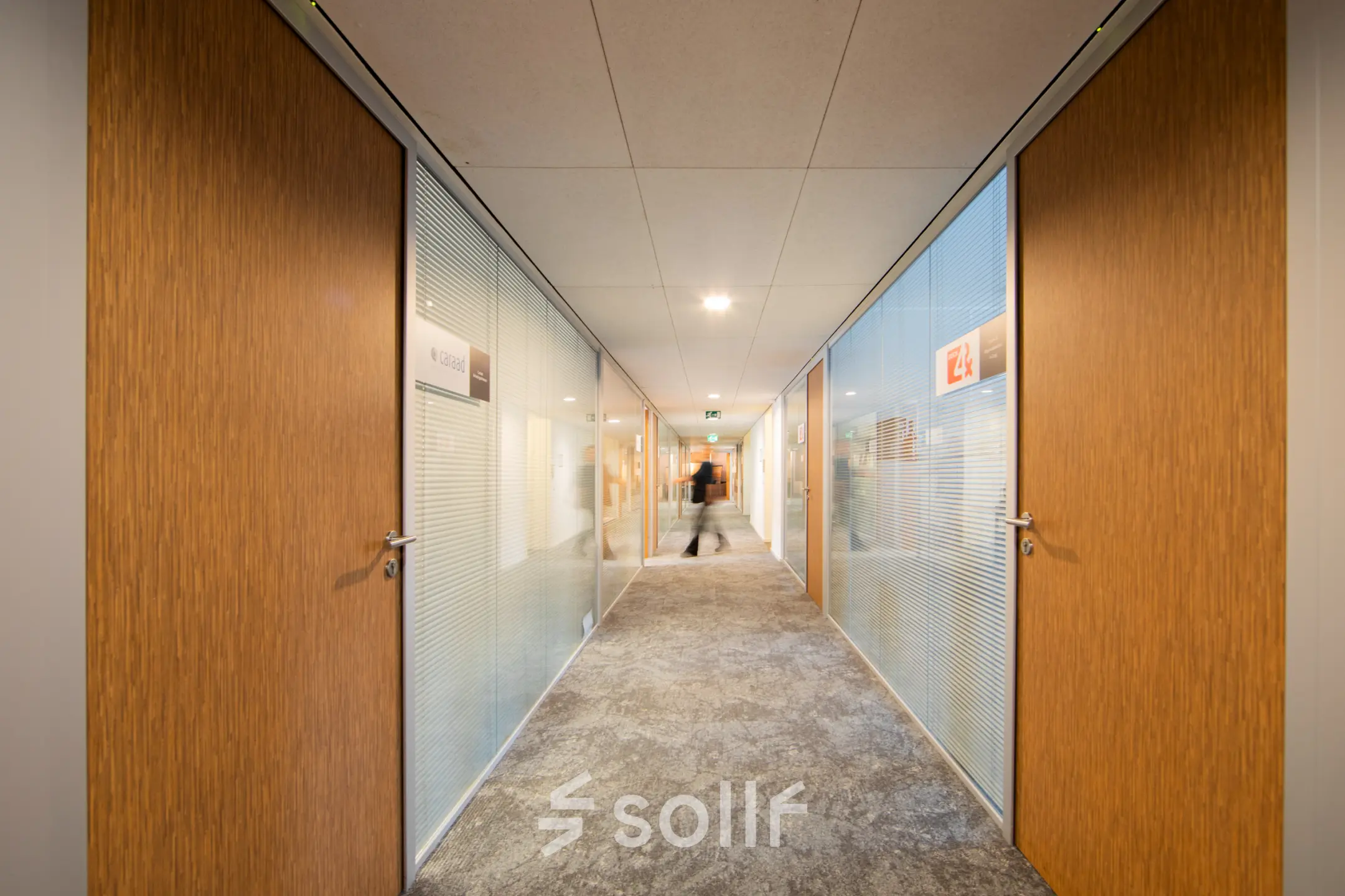 Kantoorpand op Middenburcht 136, Utrecht Leidsche Rijn met brede gang en glazen wanden. Ideaal voor kantoorruimte huren. Een persoon loopt door de gang.