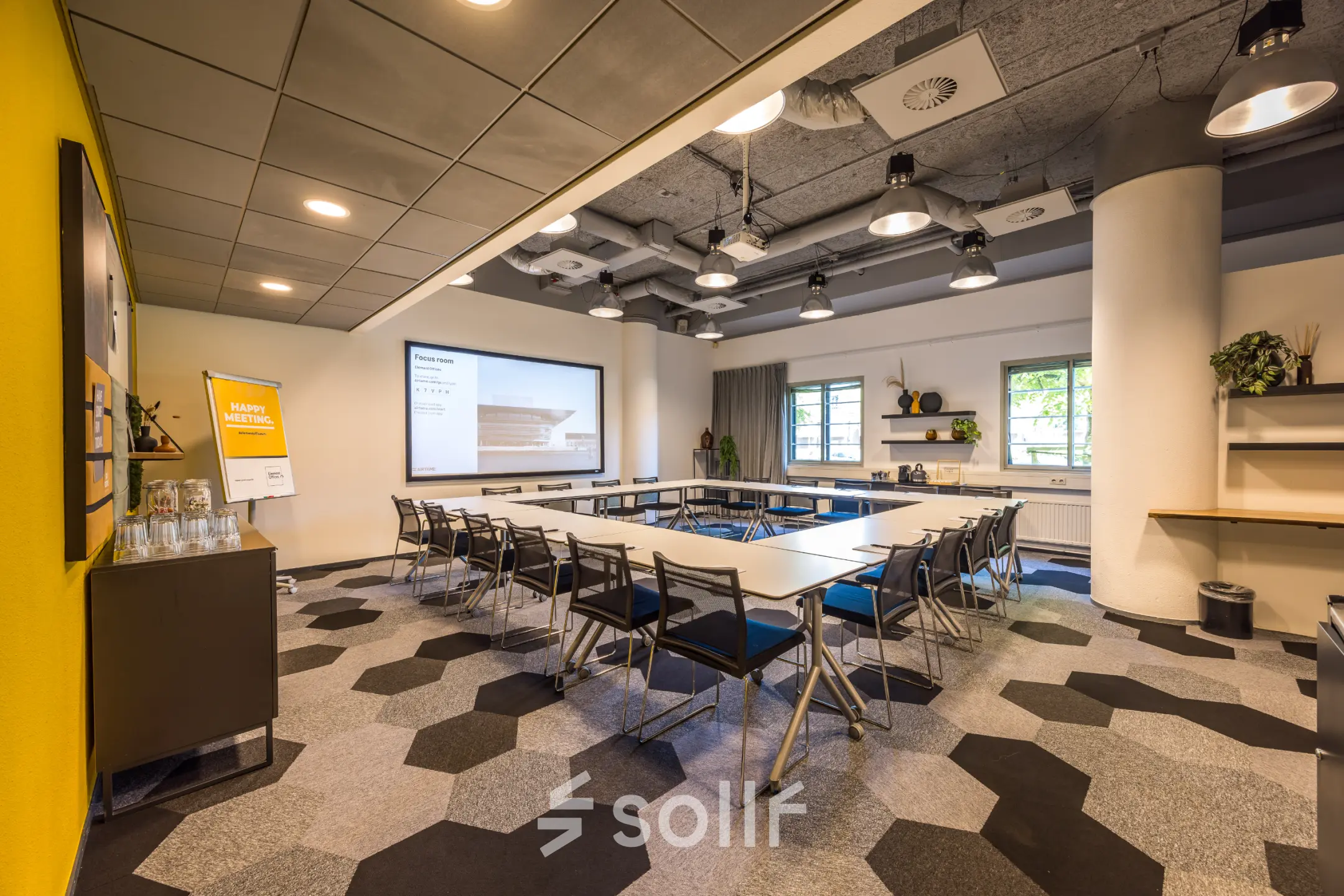 Vergaderruimte in kantoorpand op Goeman Borgesiuslaan 77, Utrecht Noord; moderne uitstraling met tafels, stoelen en projectiescherm. Ideale optie voor kantoorruimte huren.