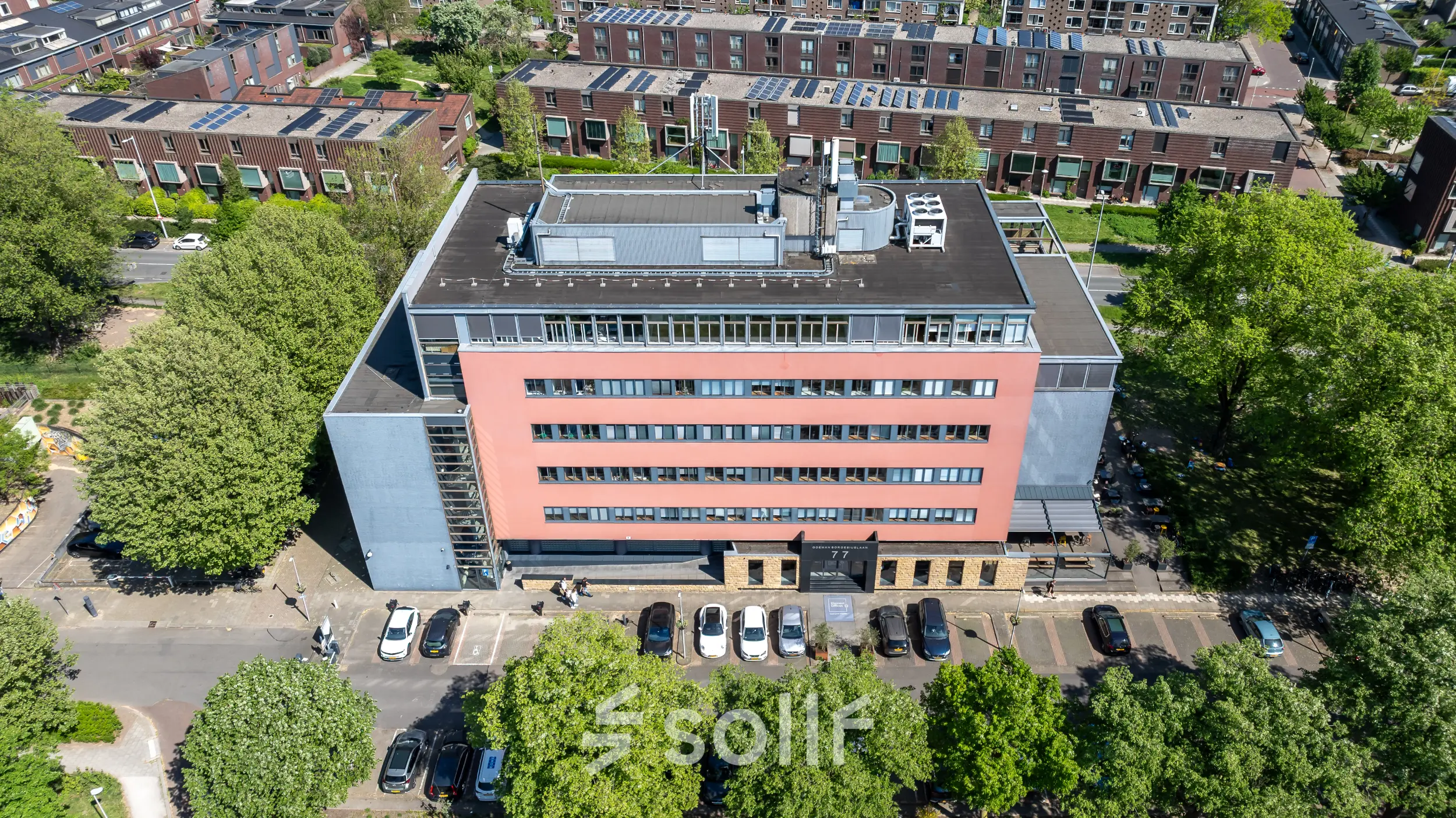 Luchtfoto van een kantoorpand op Goeman Borgesiuslaan 77, Utrecht Noord. Het gebouw heeft meerdere verdiepingen met parkeerplaatsen aan de voorkant. Ideaal voor kantoorruimte huren.