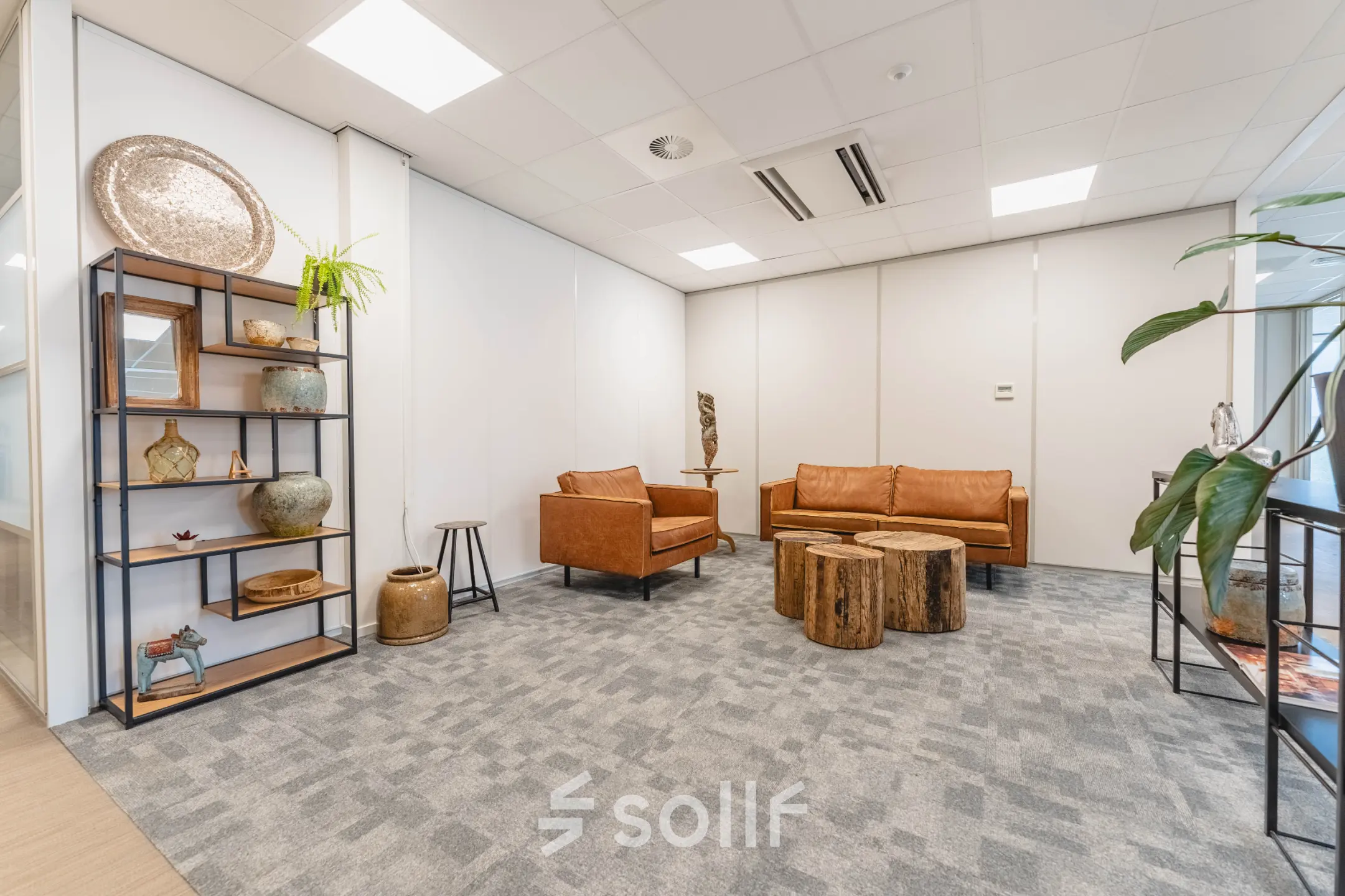 Gezellige kantoorruimte huren in Utrecht Papendorp met zitgedeelte, leren banken en houten tafels op Orteliuslaan 850. Moderne inrichting met decoraties en planten.