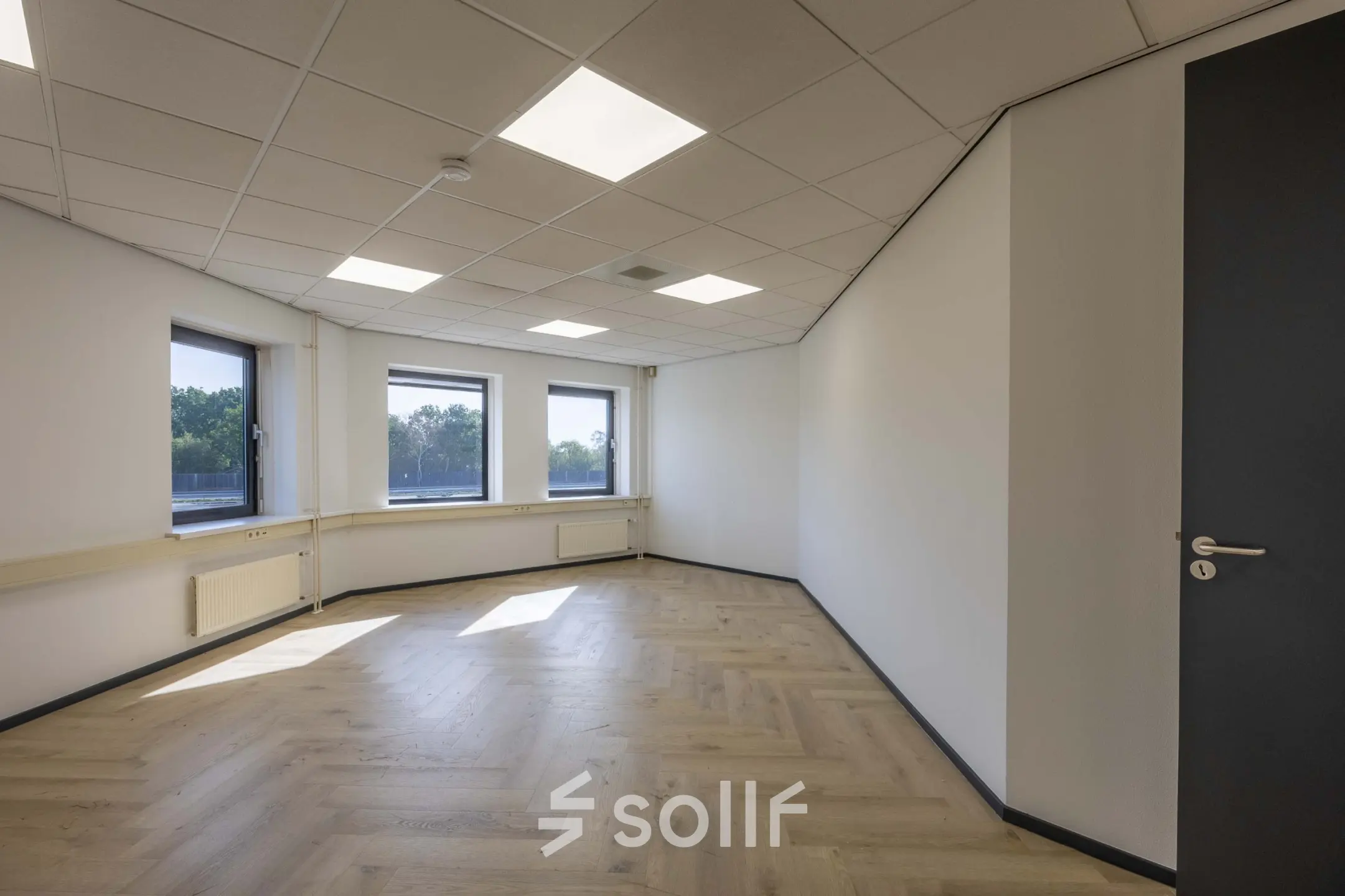 Lichte, ruimtelijke kantoorruimte te huur aan Keizersveld 47, Venray, met grote ramen en houten vloer.