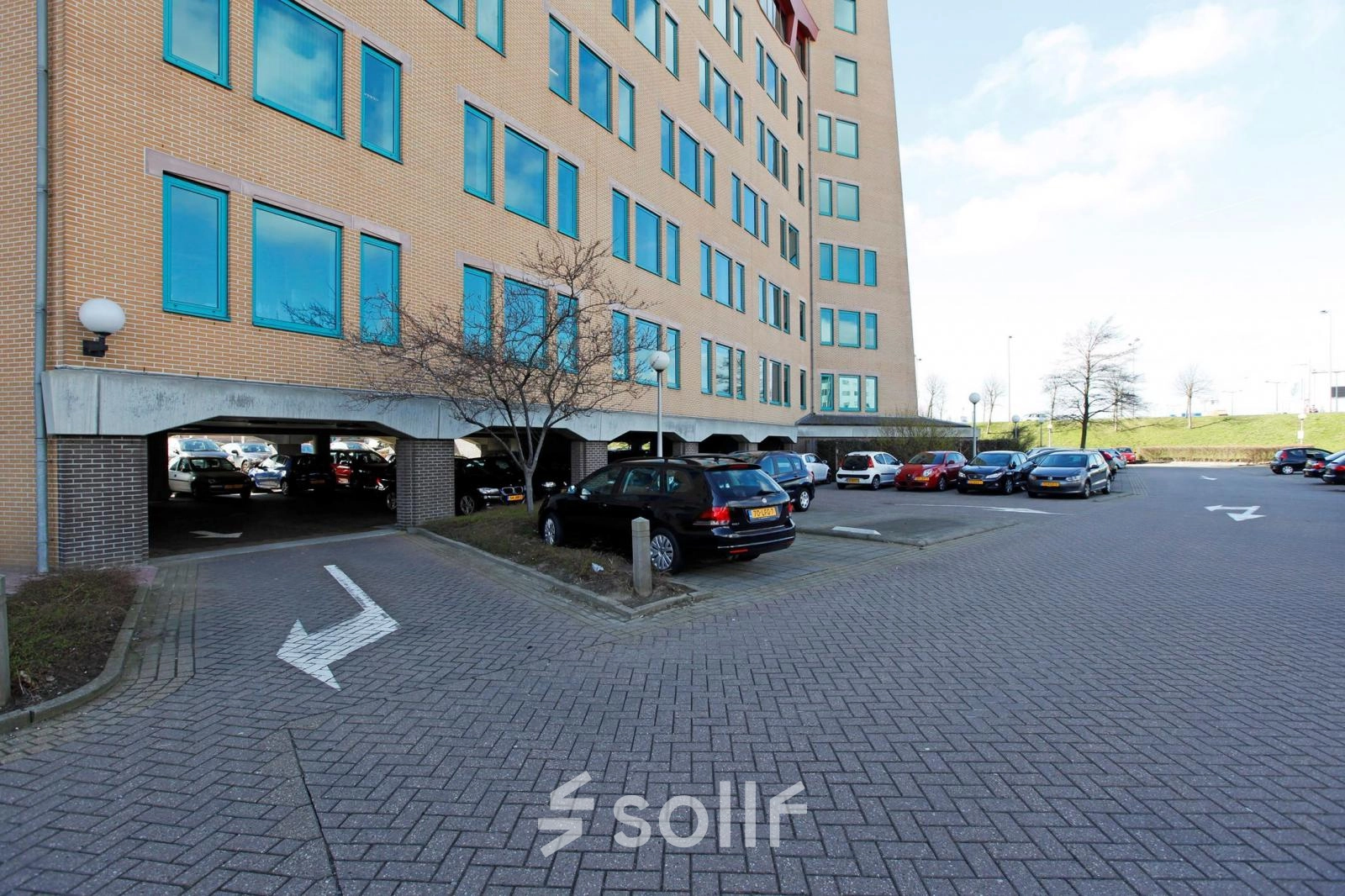 Parkeerplaats bij kantoorpand Loire 104 - 206 in Voorburg, met diverse auto's geparkeerd voor het gebouw.