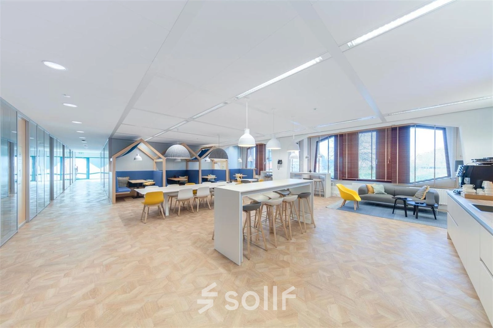 Ruime en moderne kantoorruimte in Voorburg, Loire 104 - 206, met houten vloer en flexibele werkplekken. Ideaal voor wie kantoorruimte wil huren. De ruimte biedt diverse zithoeken en een lange tafel.