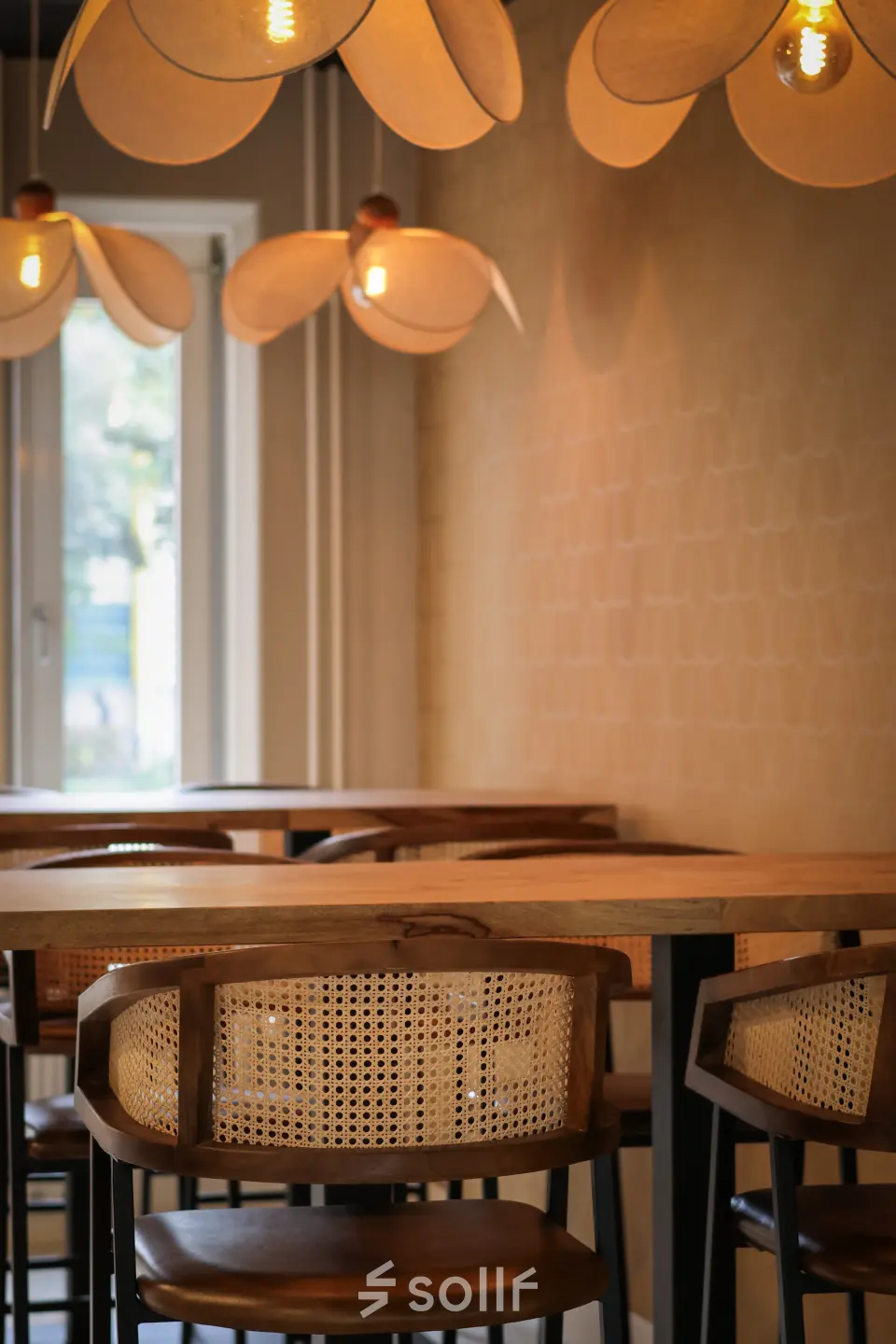 Stijlvolle lounge met houten meubilair en creatieve hanglampen, ideaal voor informeel overleg of ontspanning. Perfecte locatie aan de Vijzelmolenlaan 9 in Woerden voor kantoorruimte huren.