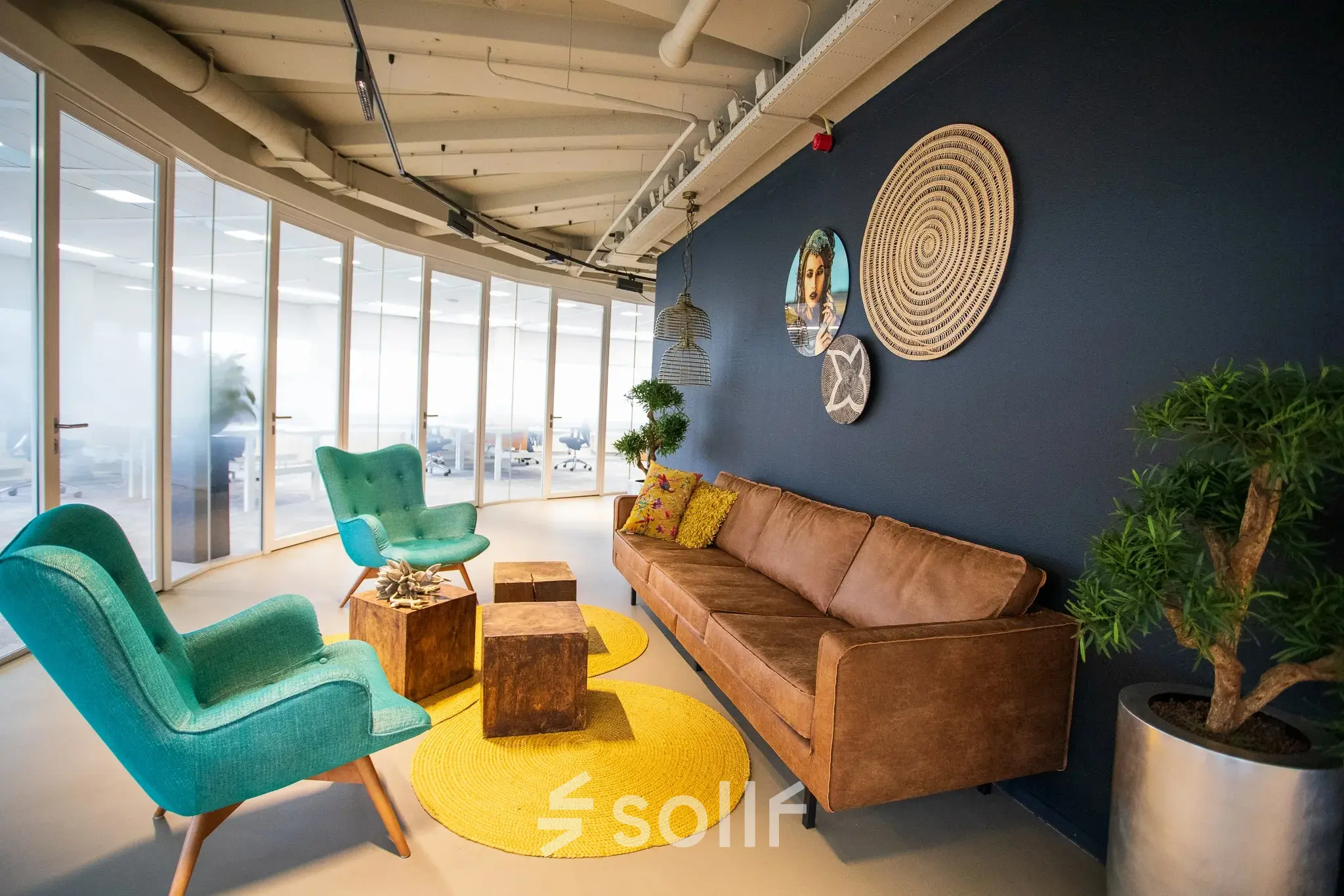 Een sfeervolle en gemeubileerde kantoorruimte in Zoetermeer, Boerhaavelaan 40, met een zithoek met stoelen, een bank, en decoratieve elementen. Ideaal voor vergaderingen of informele gesprekken. Perfect om als kantoorpand te huren.