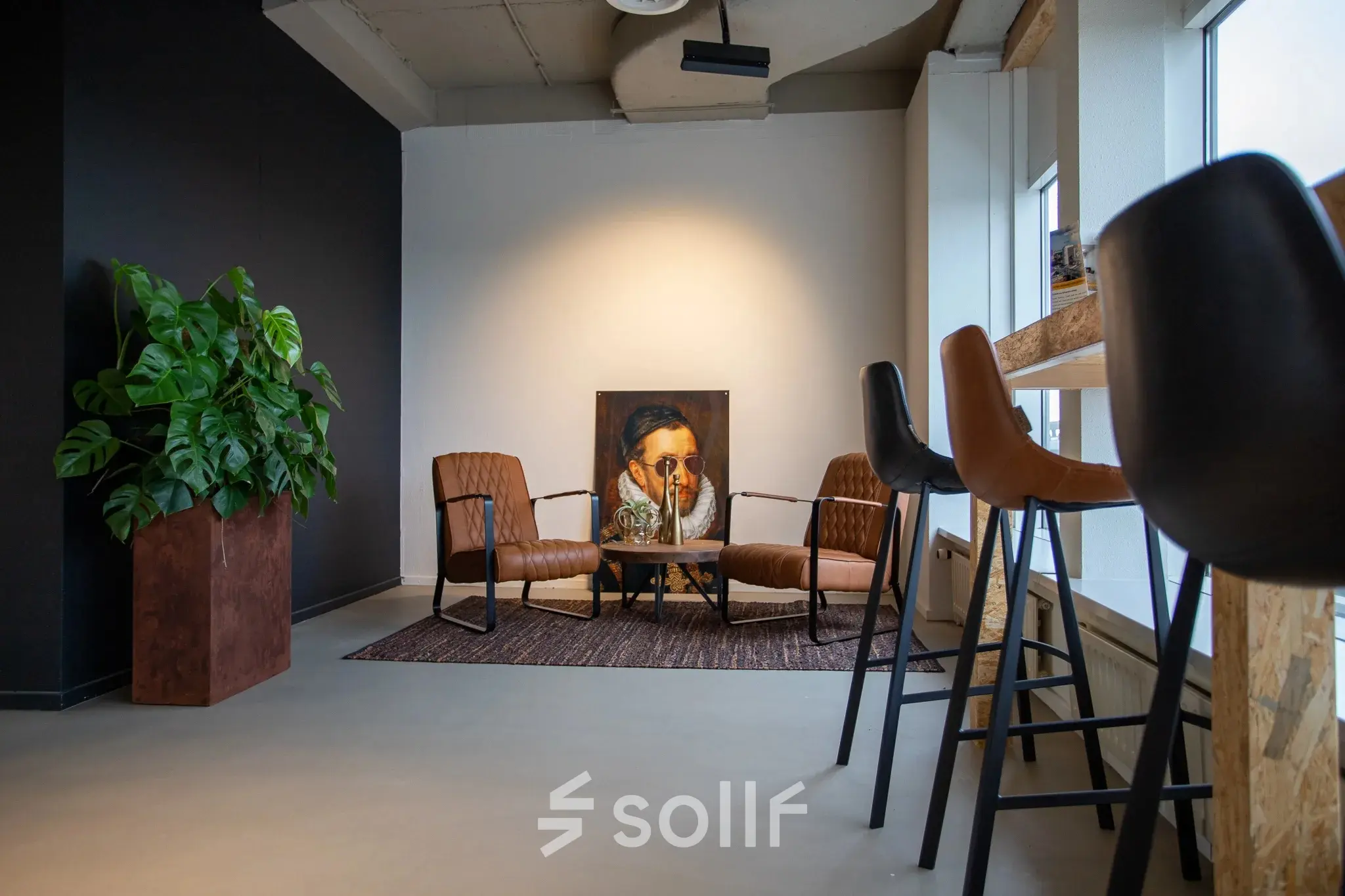 Moderne kantoorruimte op Boerhaavelaan 40 in Zoetermeer met comfortabele stoelen en een opvallend schilderij. Ideaal voor creatieve inspiratie of vergaderingen.