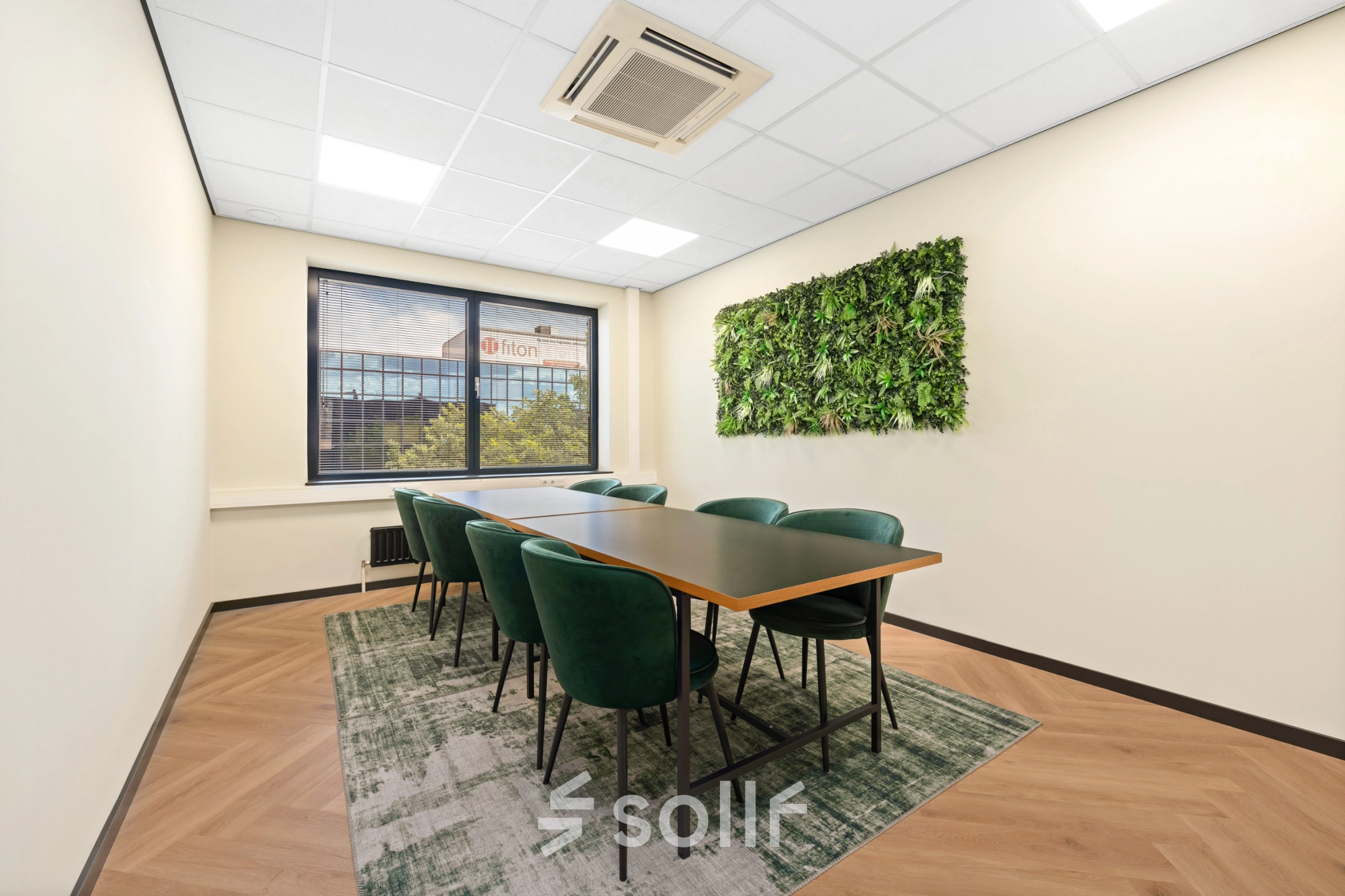 Een lichte vergaderruimte in een kantoorpand op Stationsplein 4, Zwijndrecht, met groene stoelen en een natuurlijke wanddecoratie. Ideale kantoorruimte huren voor professionele bijeenkomsten.