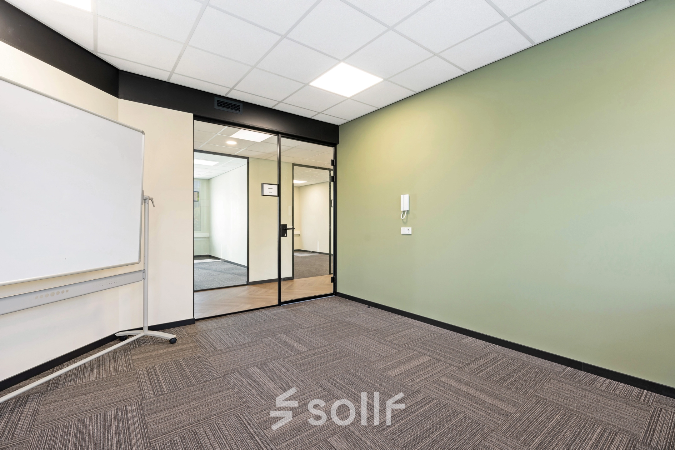 Leeg kantoorpand aan Stationsplein 4, Zwijndrecht, met modern interieur. Ideaal voor wie kantoorruimte wil huren. De ruimte heeft frisse groene accenten en voldoende licht.