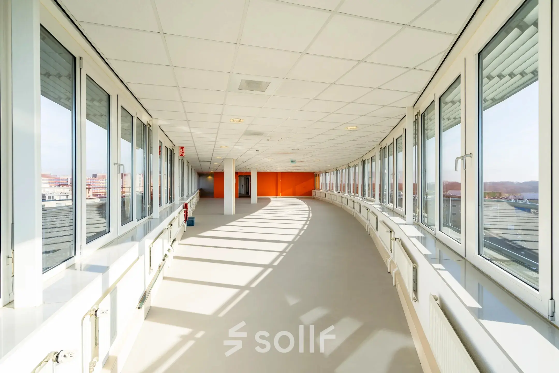 Lichte, ruime gang in kantoorpand op Dokter van Deenweg 1, met grote ramen en uitzicht over Zwolle, perfect voor kantoorruimte huren.