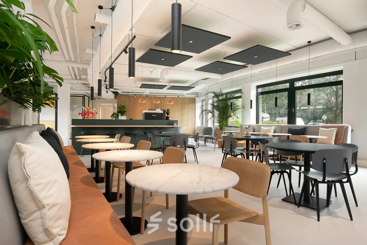Modern ingerichte kantoorruimte aan de Hanzelaan 351-361 in Zwolle, met diverse tafels en stoelen, geschikt voor werk en vergaderingen. Ideaal voor wie kantoorruimte wil huren.