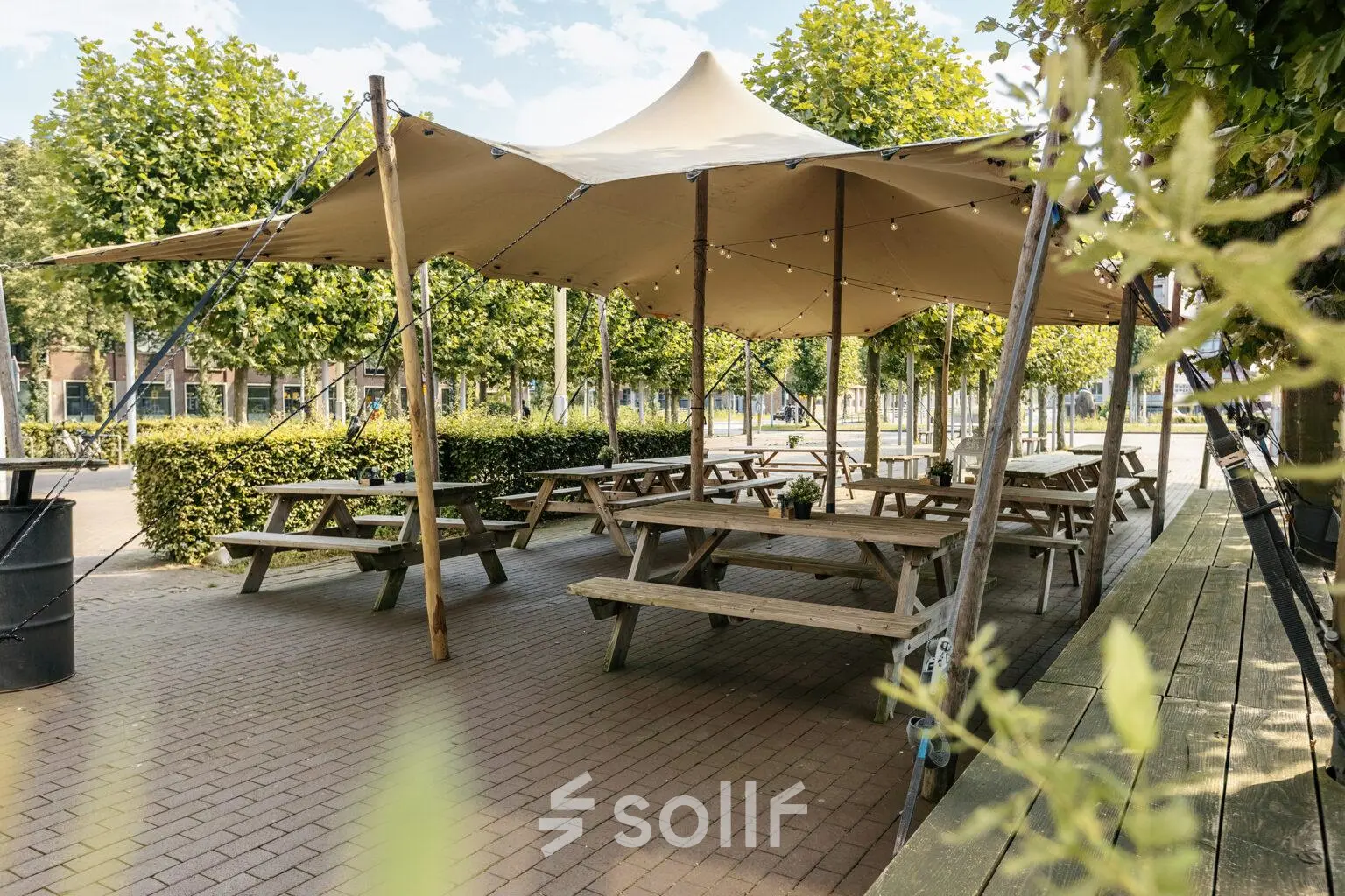 Terras bij Hanzeplein 11-27 in Zwolle met picknicktafels en een schaduwdoek. Ideaal voor informeel overleg of een ontspannen pauze buiten het kantoorpand.