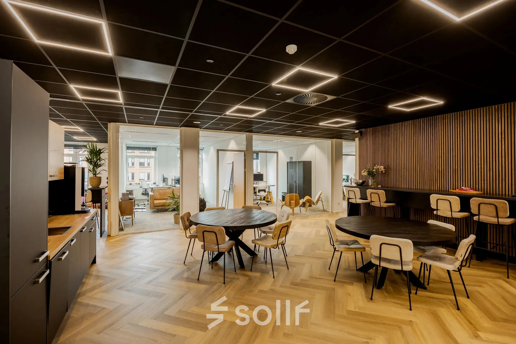 Moderne kantoorruimte te huur op Zuiderzeelaan 15-25 in Zwolle met houten vloer, ronde tafels en comfortabele stoelen. Geschikt voor zakelijke bijeenkomsten in een stijlvol ingerichte werkomgeving.